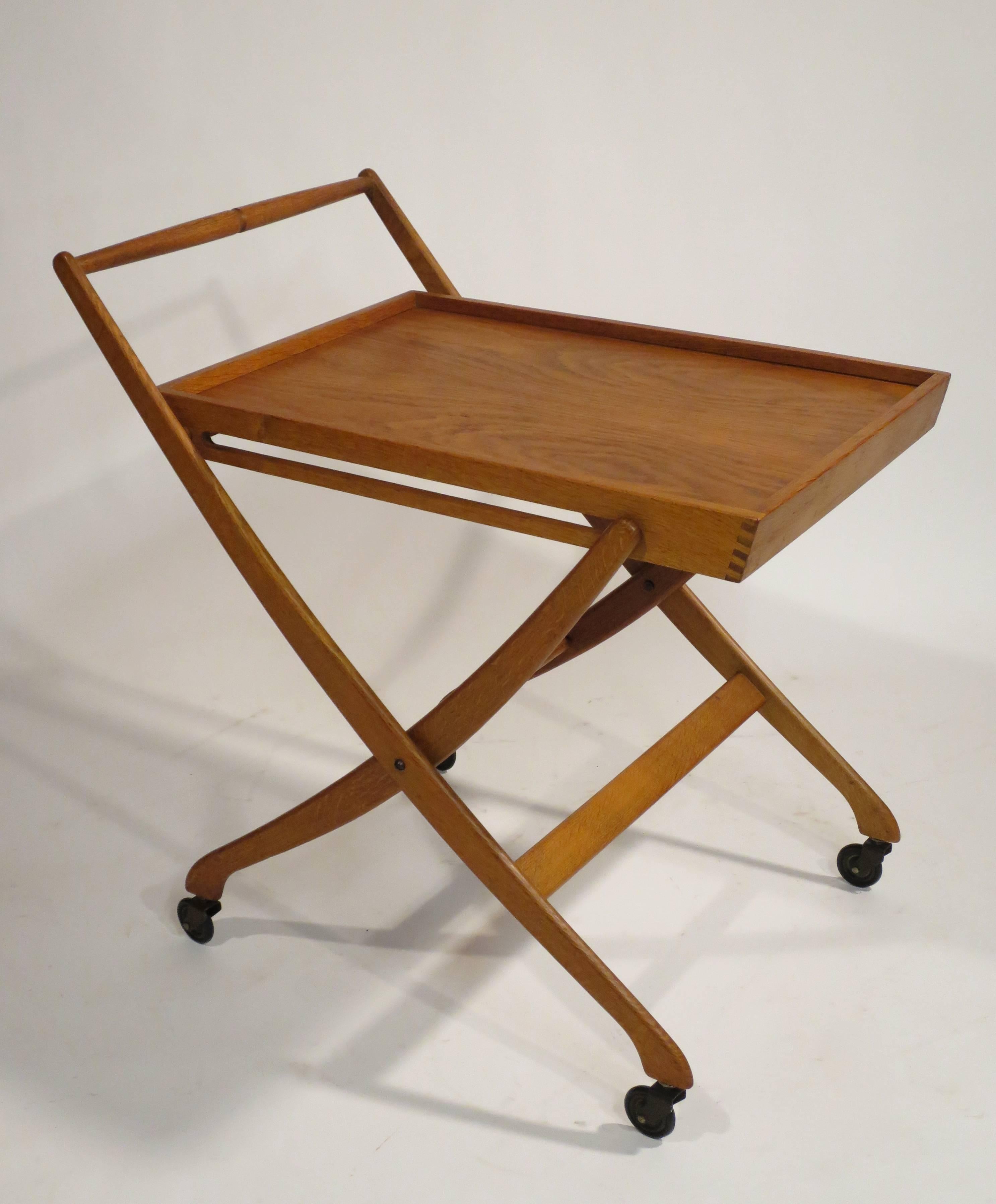 Mid-Century Modern folding bar cart. Solid oak construction with original casters. Folds flat for easy storage, circa 1960s. 
Complimentary shipping in the U.S. (lower 48).