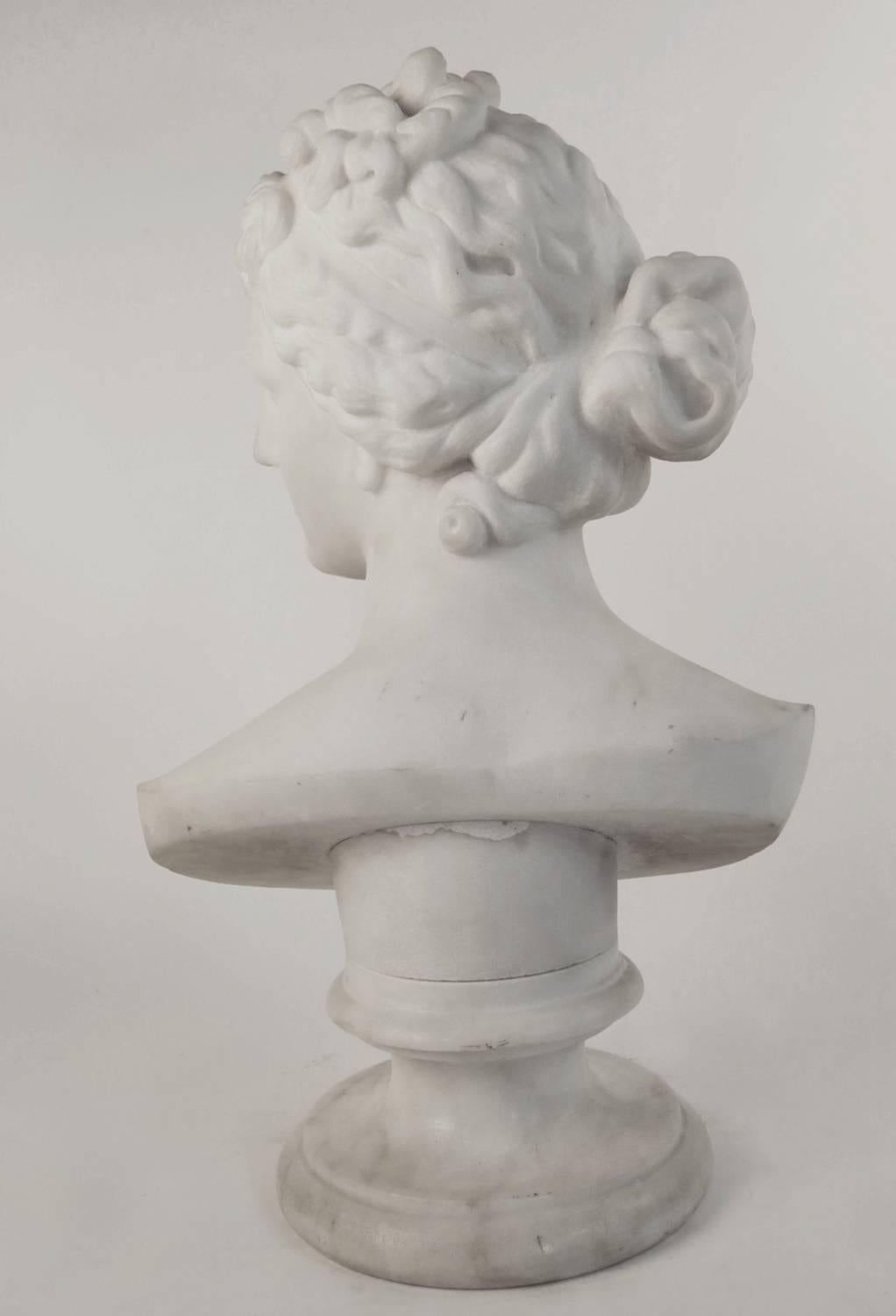 Carved in white Carrara marble, the bust finely modeled and raised on a marble socle.
