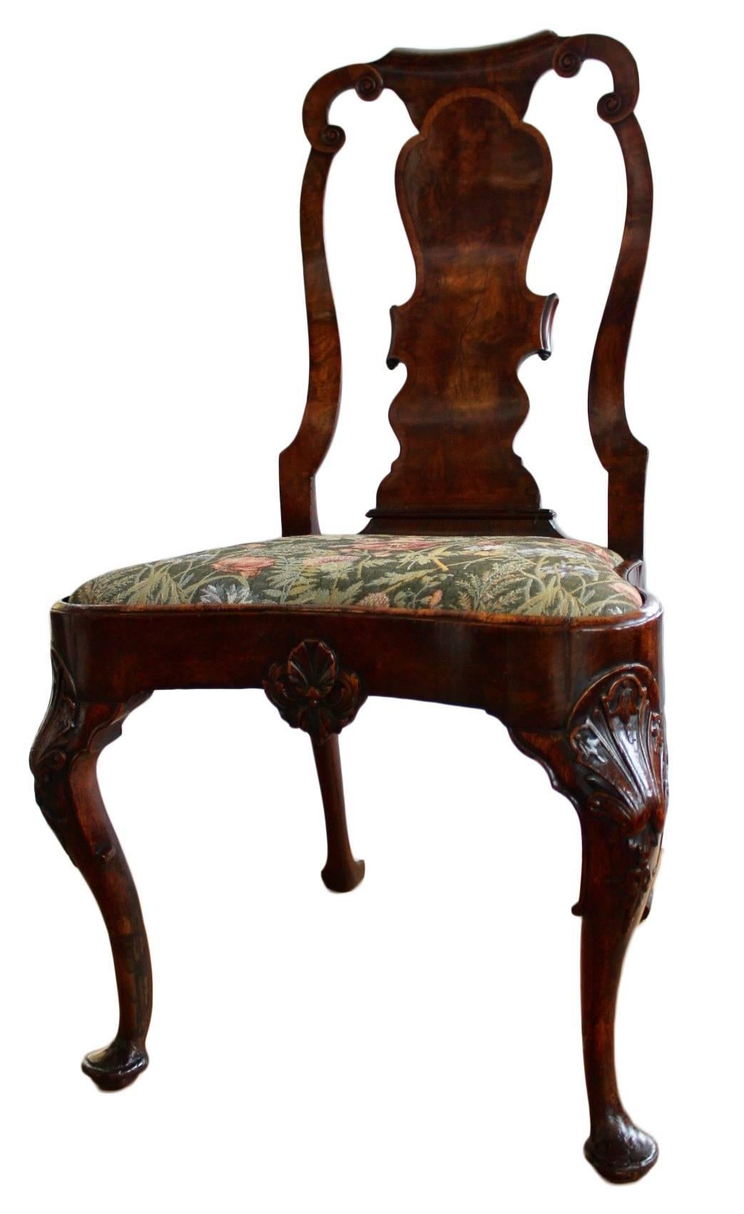 The scrolled top rail over a shaped veneered backsplat and slip seat, raised on cabriole legs carved at the knees with a shell motif, centering a foliate carved 
 crest.