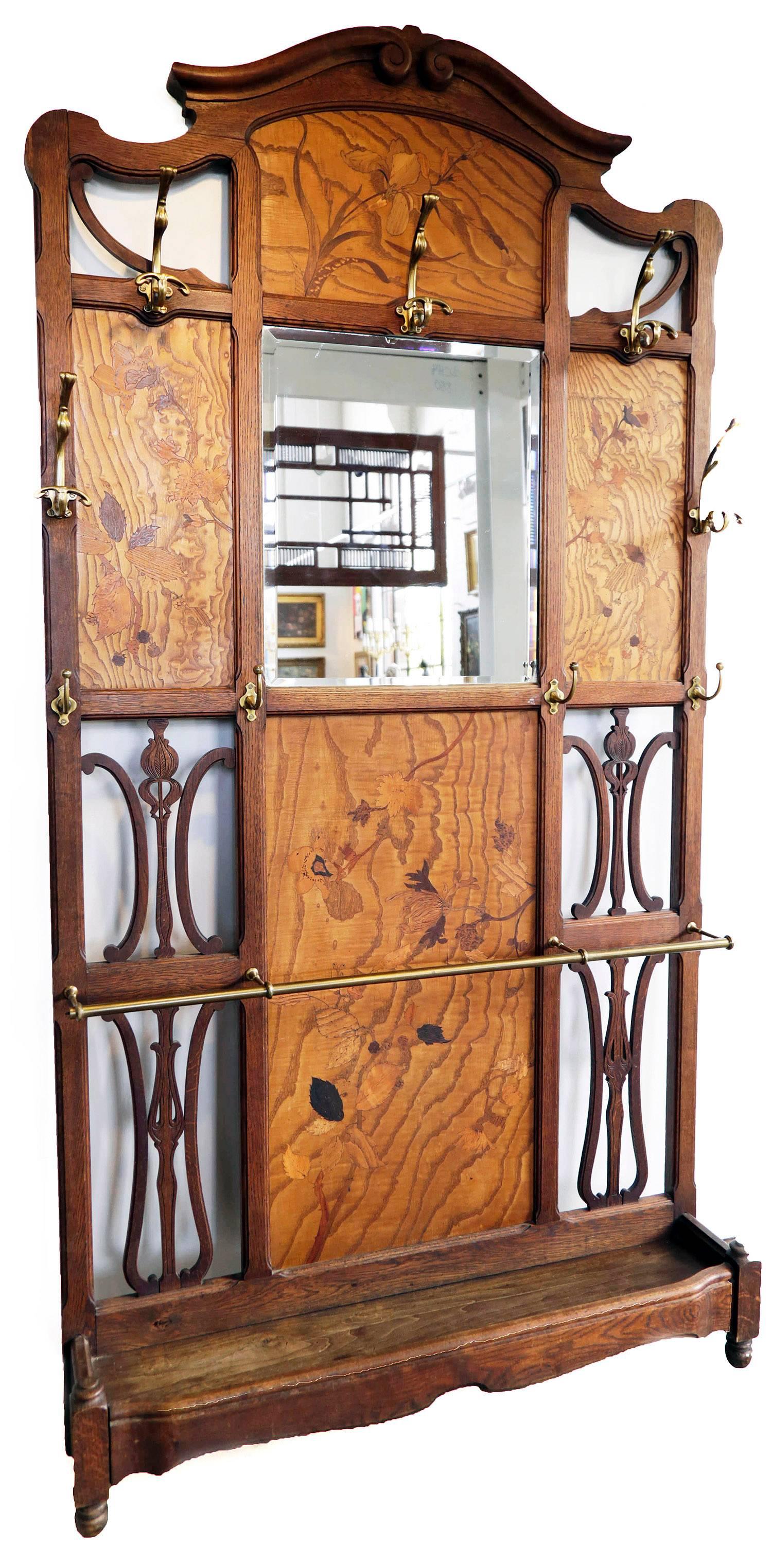 19th century French Art Nouveau hall tree
tripart form with mirror in center, with four wood panels inlaid with leaf and floral forms.