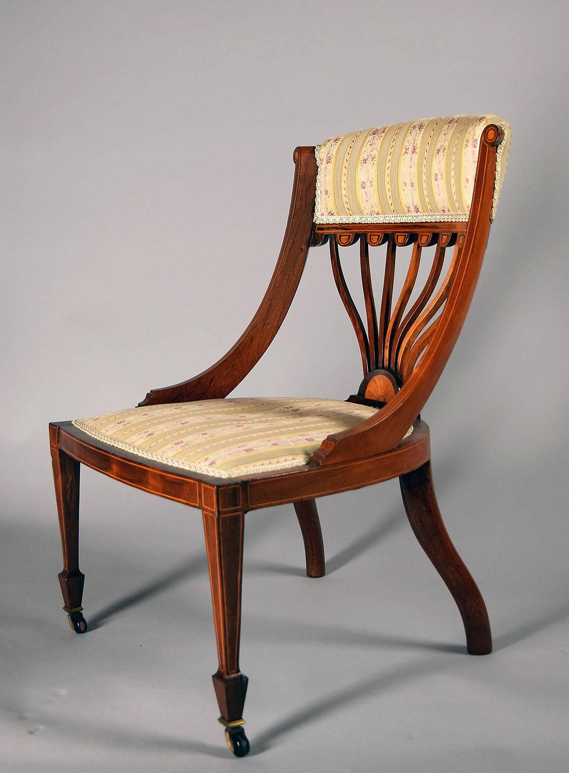 With upholstered crestrail centering line inlaid scroll uprights over a tablet back with inlaid demilune pendant medallions, the upholstered seat on squared tapering legs ending in spade feet and casters.

Provenance:  Roundwood Manor, Hunting