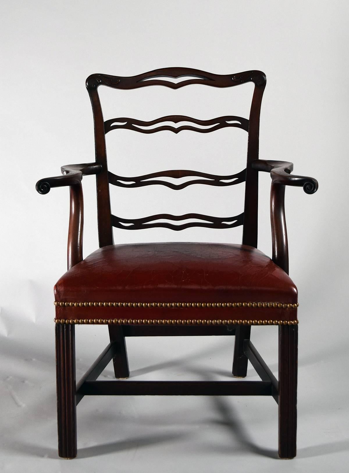 Each with serpentine pierced crestrail above three carved and pierced splats over upholstered seats with shapely armrests flanking, on squared fluted legs joined by stretchers.

Provenance: Roundwood Manor, Hunting Valley, Ohio.