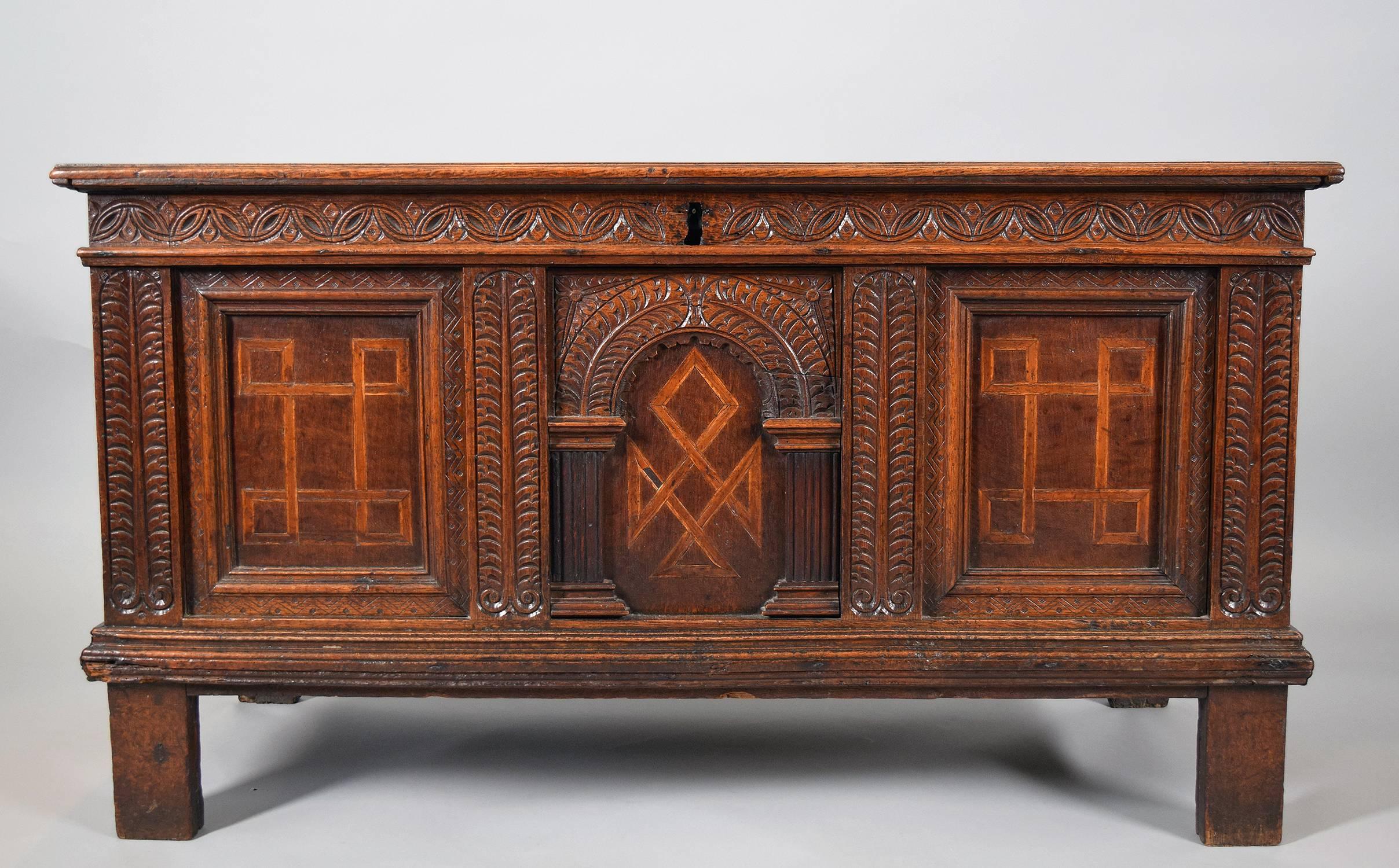 The rectangular molded top above a front carved with an arch and stylized foliage with inlaid panels, the sides also panelled, raised on rectangular feet

Provenance: Roundwood Manor, Hunting Valley, Ohio.
