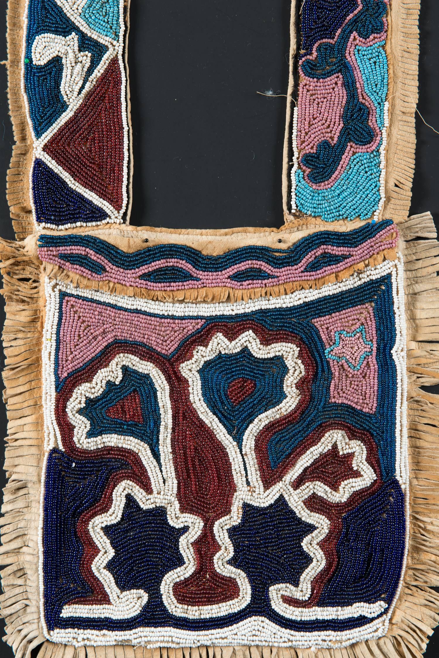 Region / Tribe: Oklahoma territory Delaware / Creek-Cherokee, 

circa 1860s

Material: Native tanned deer hide, cotton thread, glass beads

Dimension: L. 34” x W. 10” (bag), W.of bandolier with fringe 3” 

Collection History: Private