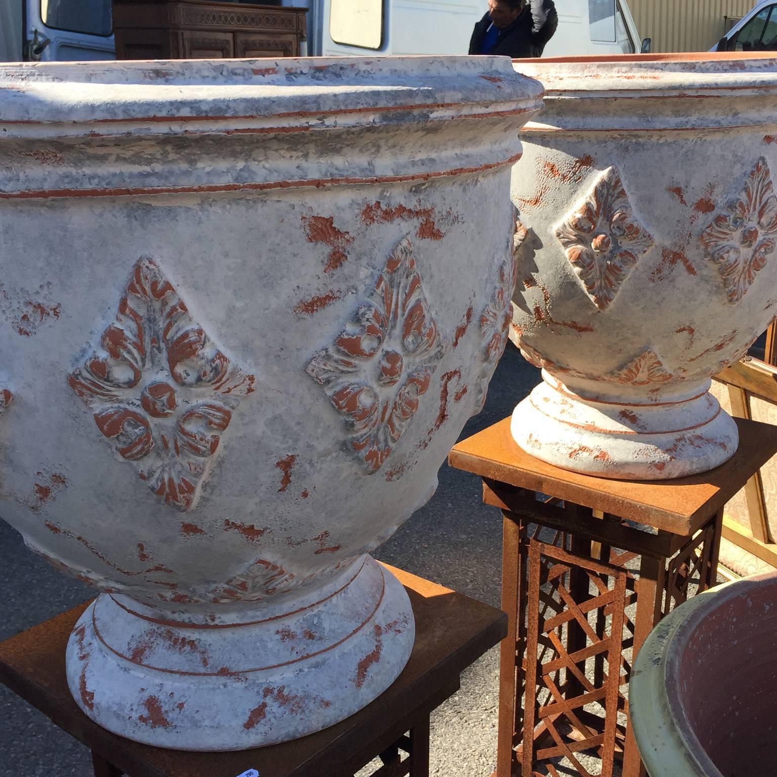 A pair of beautiful anduze terracotta planters/urns crafted in the South of France by reputable artisans. The patina on these planters is absolutely stunning and unique, with hints of antiqued orange, grey and creams. Hand thrown, modeled and