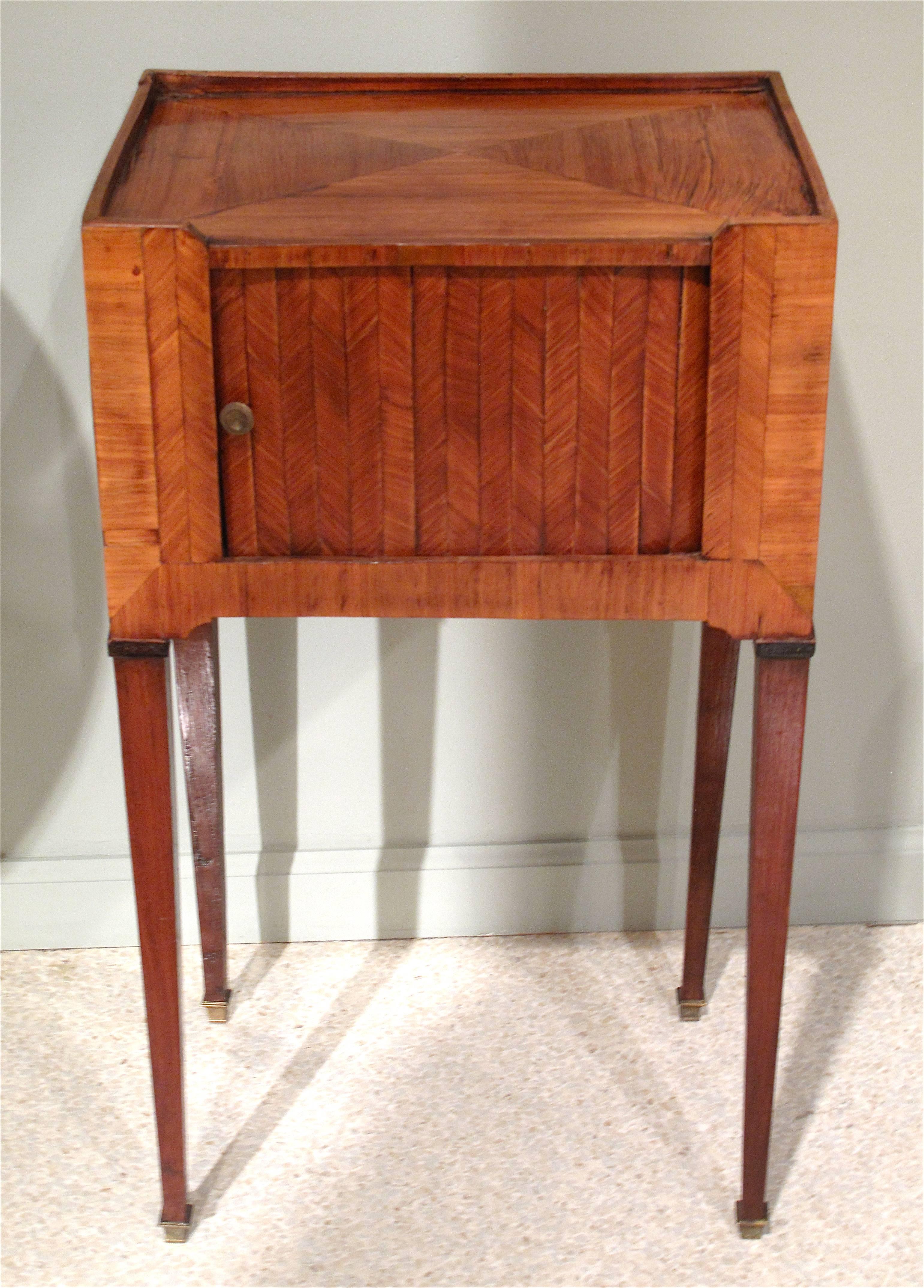 A fine tambour fronted tulipwood marquetry table, ca 1780, originally used as a bedside table. The tambour is in excellent working condition. The marquetry is finished and very attractive on all four sides.