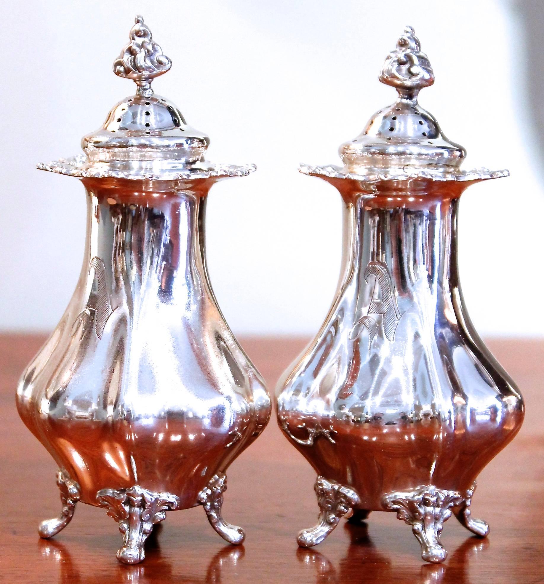 A handsome pair of tall footed shakers of unusual form, with distinctive flame finials, made by the distinguished New York City jewelry firm Black, Starr and Frost, founded in 1876 and active under that name until 1920. Both engraved with the