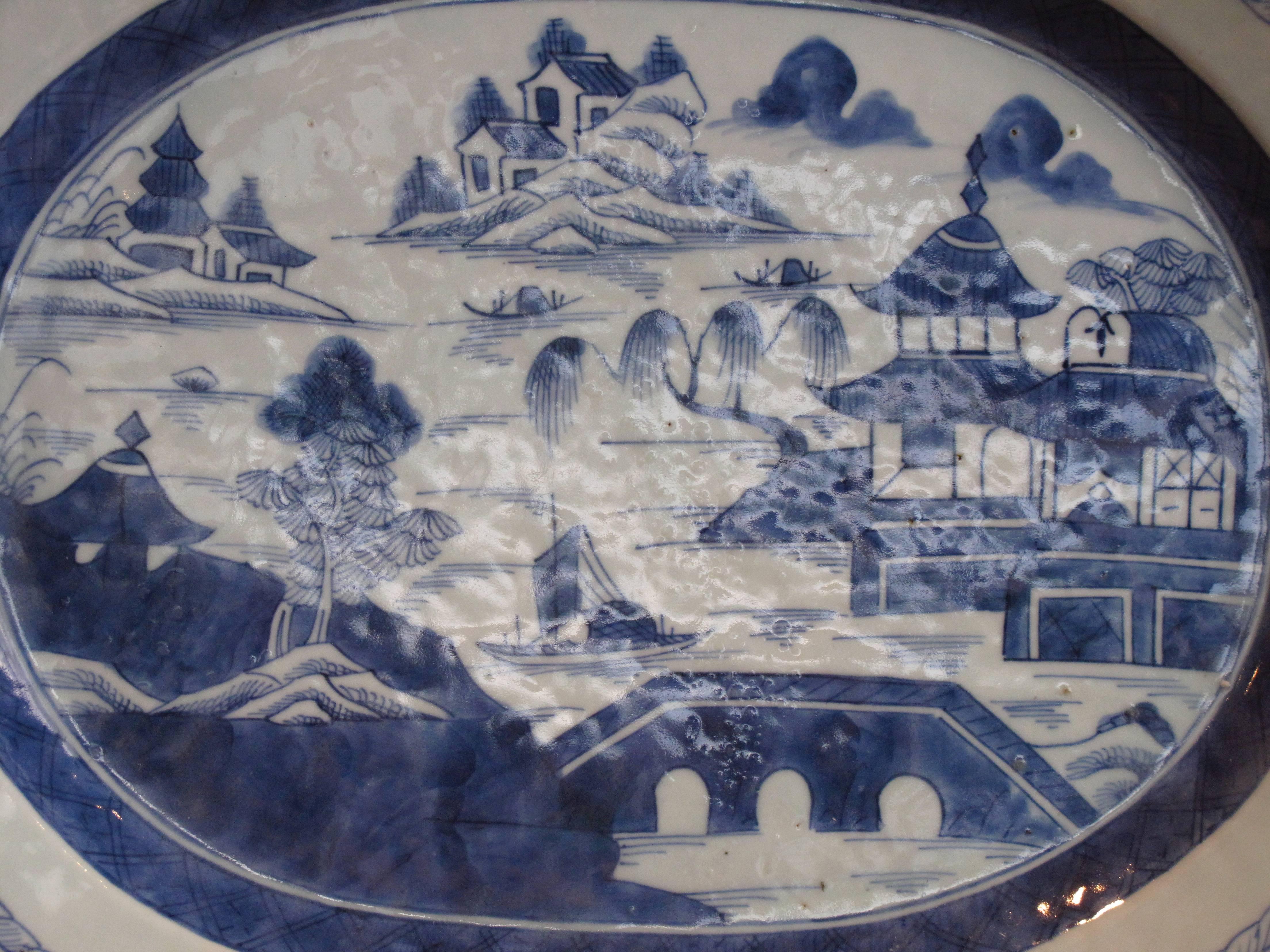 A ca. 1860 Chinese export blue and white platter with a shaped rim enclosing the traditional decoration of estuary scenes with temples and a bridge.