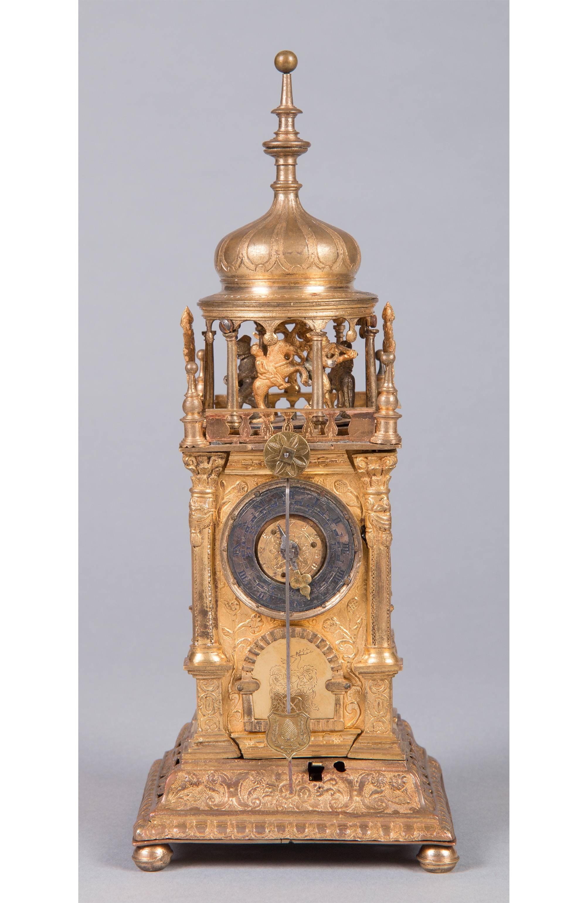 Marking punch: “I.M.”
Augsburg, circa 1600
Measures: Height 30 cm
Gilt brass case with figural motifs in Églomisé work and figure automat, copper tower-form, striking work with chain and fuse and alarm in the plinth area, three windings and two