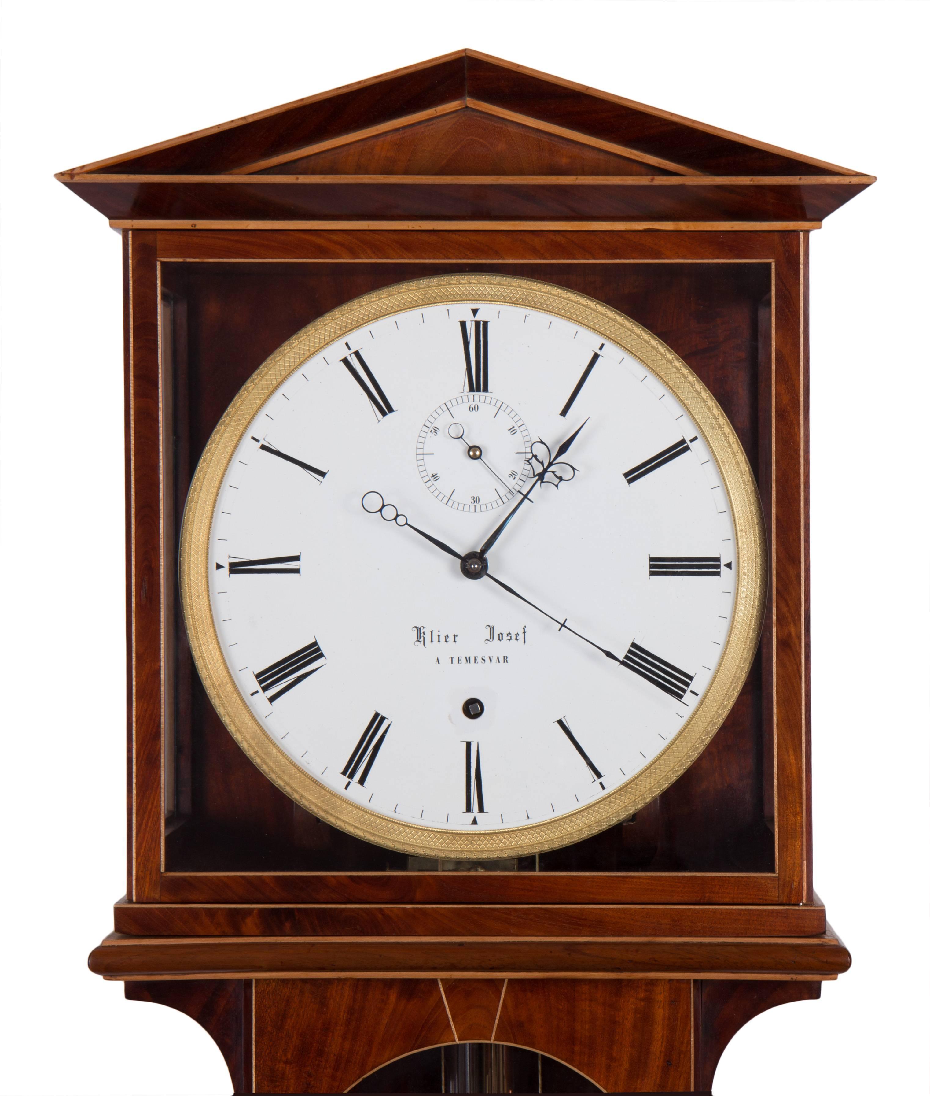 Measure: Length 150 cm, duration 31 days,
Mahogany veneered case with maple stringing, enamel dial with steel hands,
fire gilt bezel, Graham escapement, second’s beating compensation pendulum in brass and steel after Elicott.
 