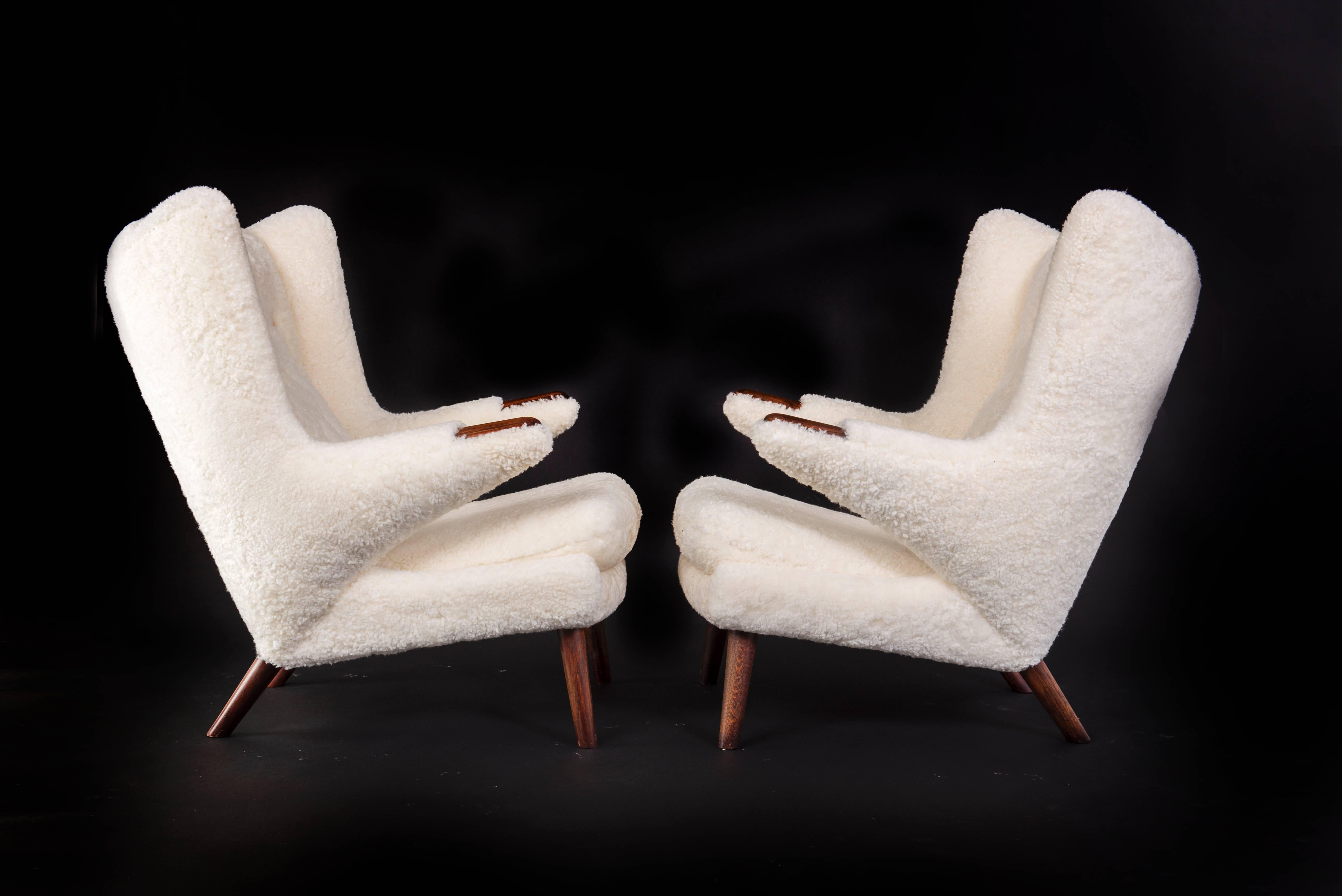 Hans J. Wegner pair of papa bear easy chairs and stool.

Rosewood nails, teak legs. Sides, back and loose cushion with sheepskin. 

Stool in teak and sheepskin.

Manufactured by AP-Stolen, Copenhagen. 

Designed 1951

1 chair