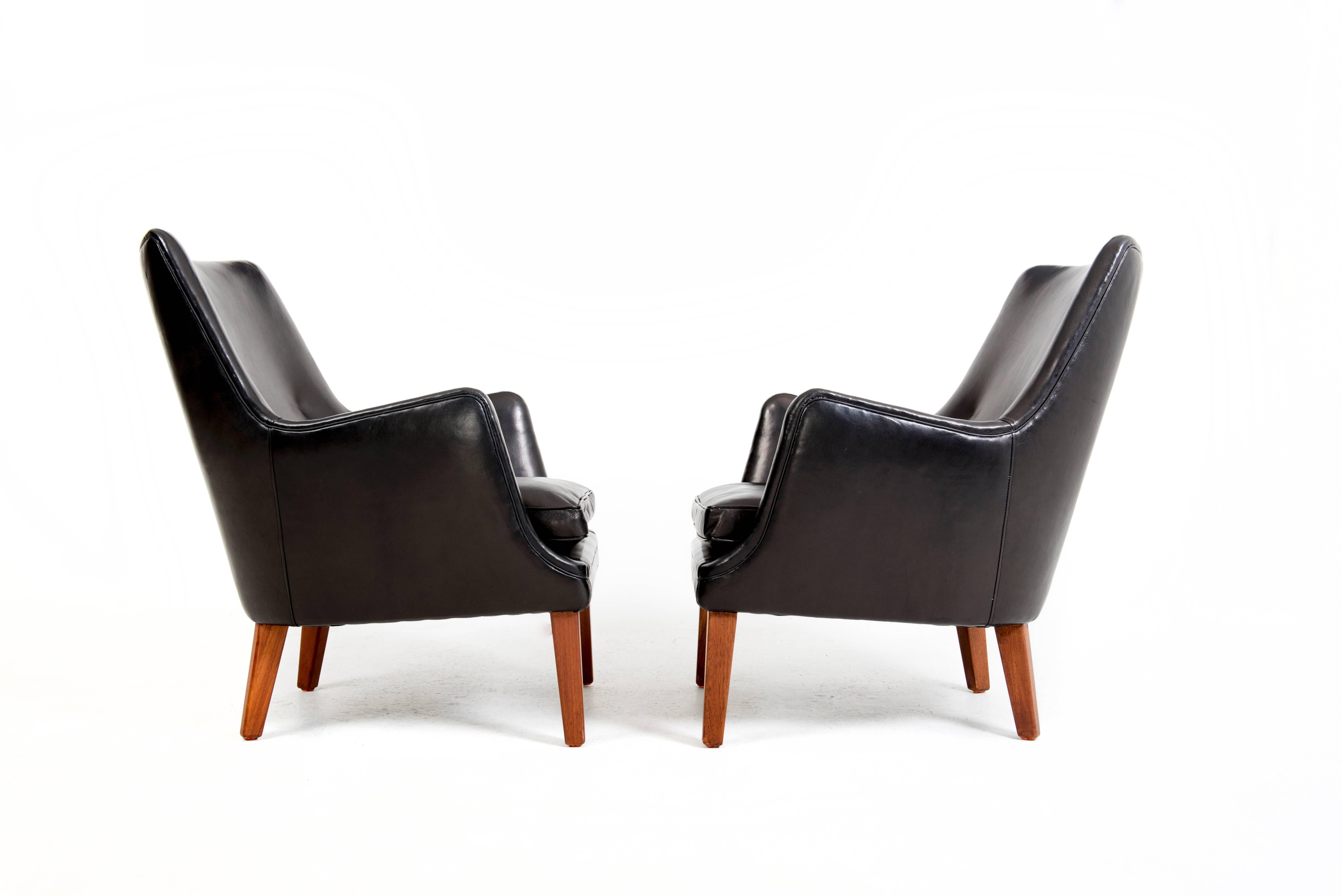 Arne Vodder.

Easy chairs with teak legs. Sides back and loose seat cushion upholstered with black Niger leather. 

Designed in 1953.
Made by upholsterer Ivan Schlechter.