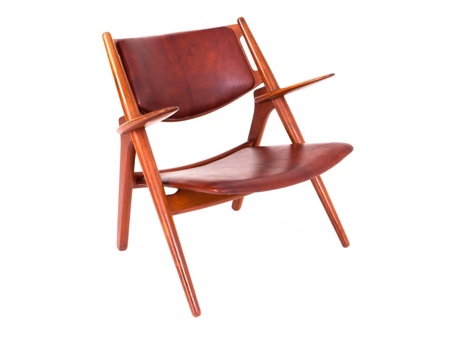 Hans Wegner.

Sawbuck easy chair.
Oak frame, teak back, seat and back with cognac-colored leather.

Designed 1951.
Produced by Carl Hansen & Søn.
Model CH-28.
  