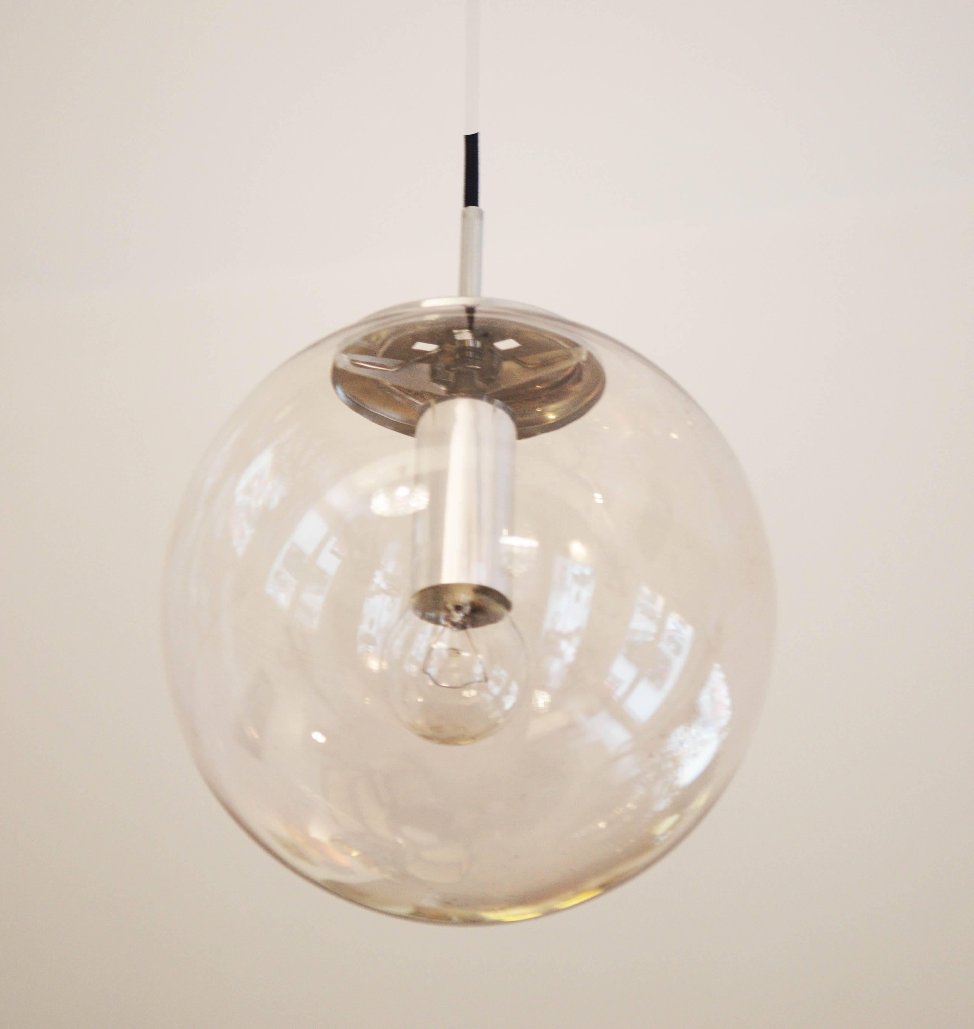 Large ball pendant by Glashütte Limburg model 4103rd.
The ball is handblown and consists of crystal antique glass.
Small bubble inclusions provide a great lighting experience.
The structure and the canopy is made of chromed metal.
The cable is