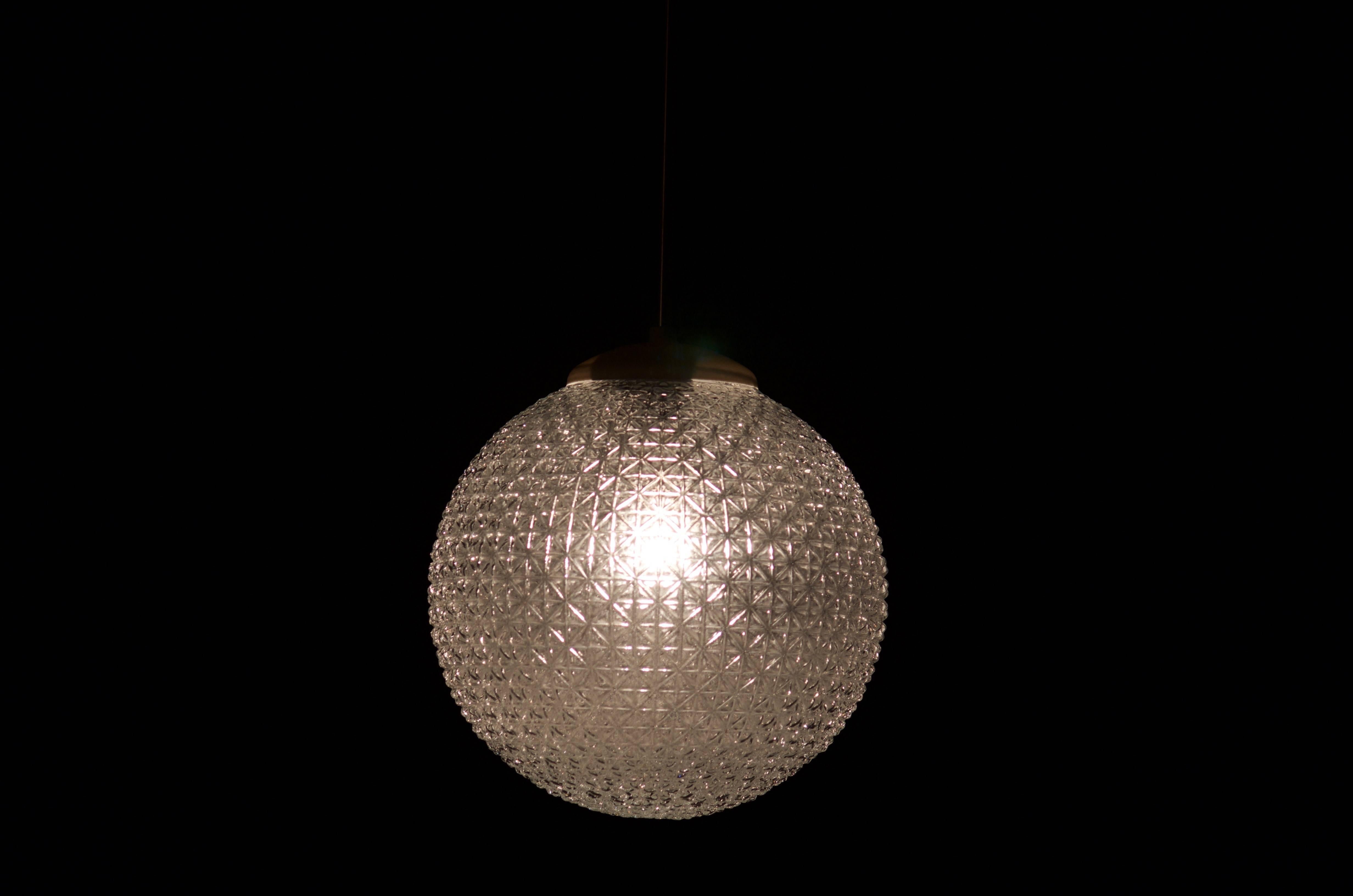 Globo in vetro pressato con inserto in bachelite e una lampadina E27 degli anni Sessanta.
fino a 40 pezzi disponibili.