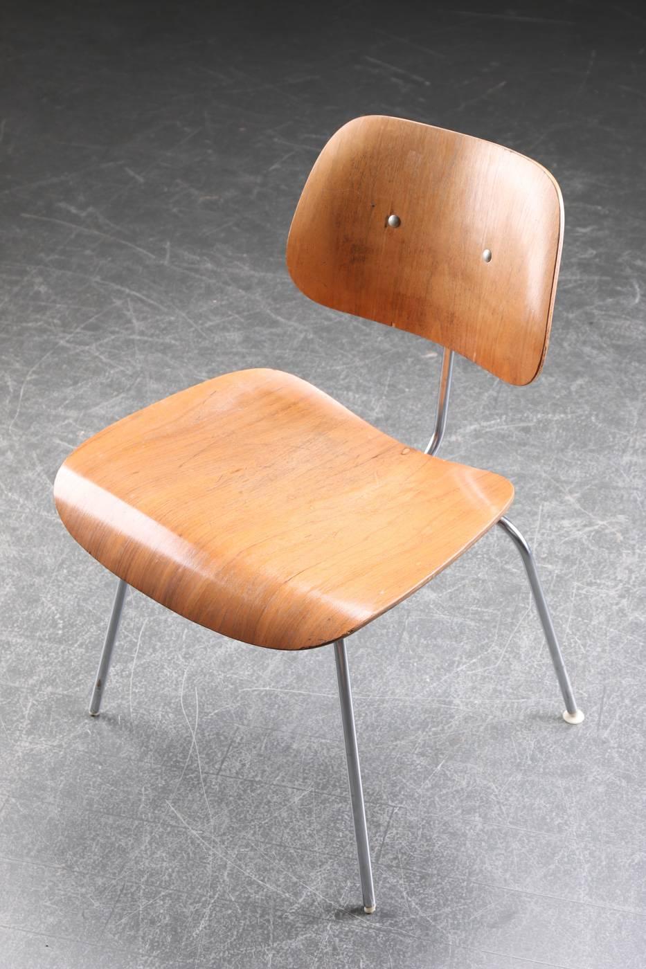 Charles Eames DCM dining chair with seat and back of molded walnut veneer, chromed steel. Designed by Charles and Ray Eames in 1946. Produced by Herman Miller, model DCM. Signs of wear and small chips to veneer. Frame under seat with welding.