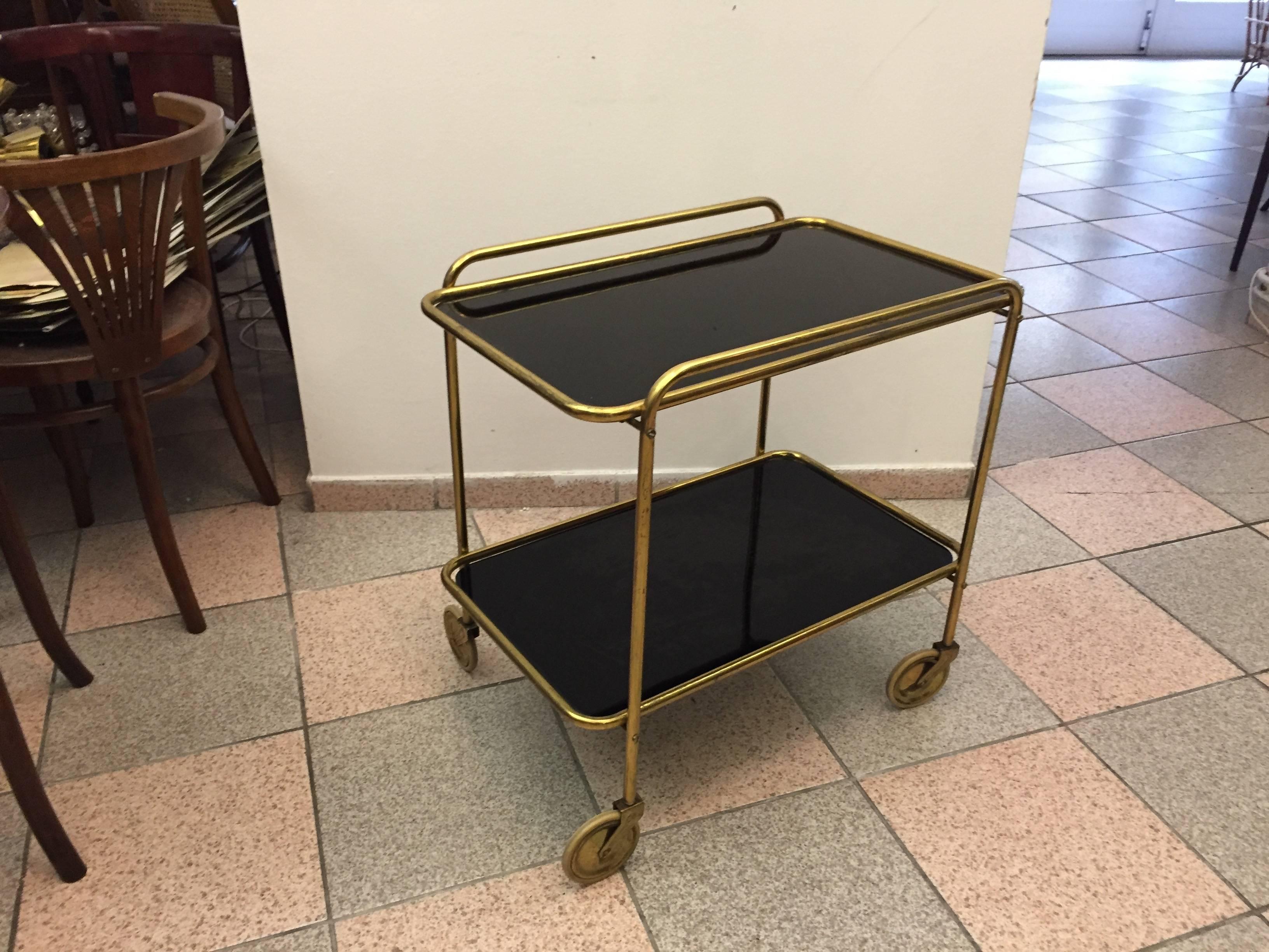 Brass frame on four wheels with two black glass plates, made in Italy in the 1960s.
Original condition.