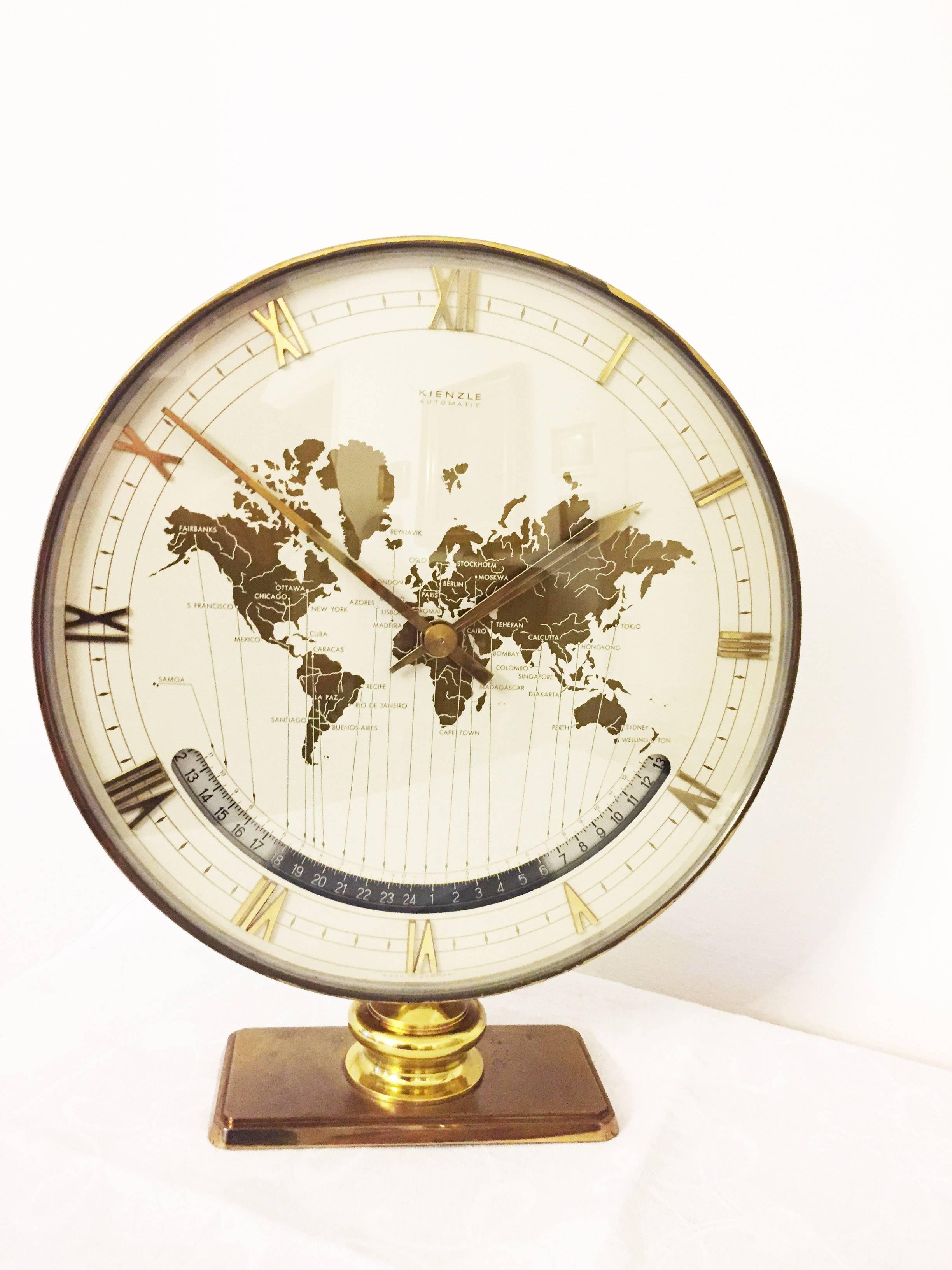 Kienzle automatic world timer zone clock.
An exclusive big table clock from Ø 26cm wonderful clocks face with world map and world time zones, crystal glass, the heavy case and base are of solid brass. Battery movement. The most of Kienzle clocks