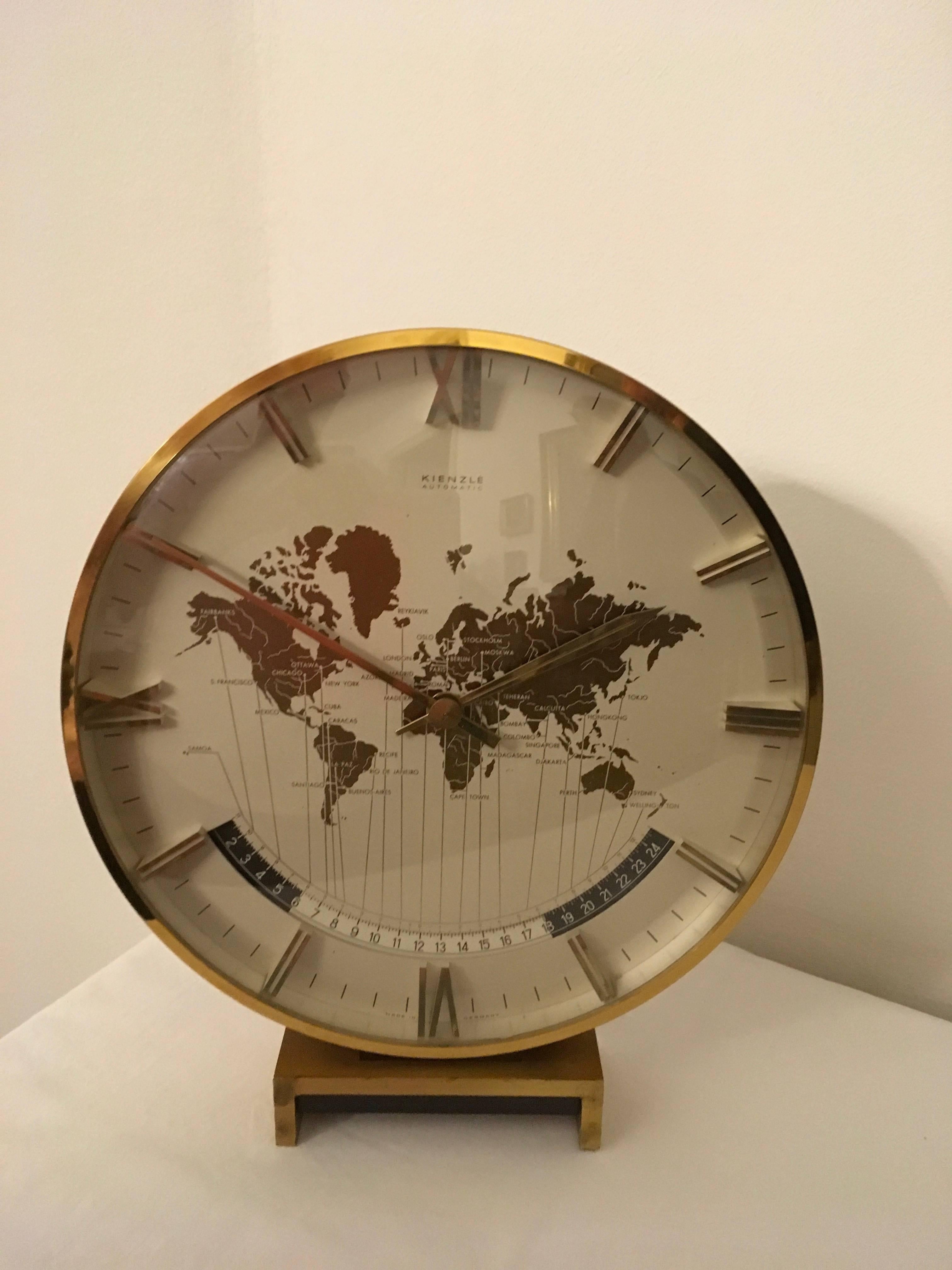 Kienzle automatic world timer zone clock.
An exclusive big table clock from Ø 26cm wonderful clocks face with world map and world time zones, crystal glass, the heavy case and base are of solid brass. Battery movement. The most of Kienzle Clocks