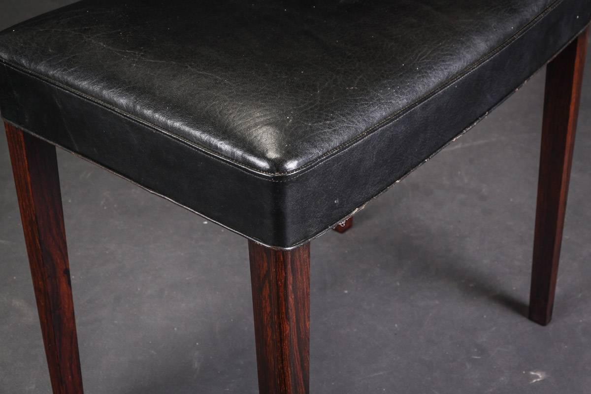 Stool upholstered in black leather, legs of Rio rosewood. Made by an unknown furniture maker in Denmark in the 1960s. 
Cites certificate included
Measures: H 50, L 54, B 36.