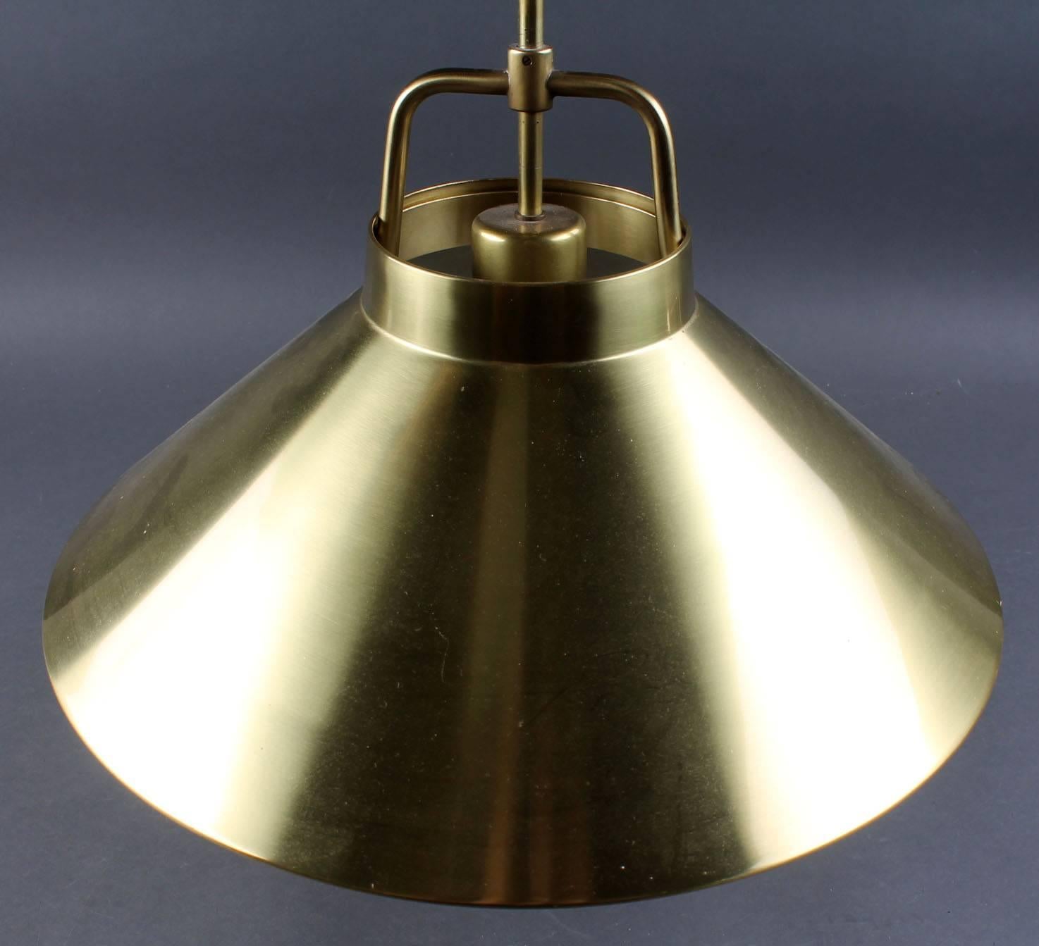 Brass pendants designed by Frits Schlegel and produced by Lyfa in the mid-1960s. Brass mounting bracket with adjustable height. Model P 295.
Measures: H. 27 cm. Ø 44 cm. 
Two pieces available.