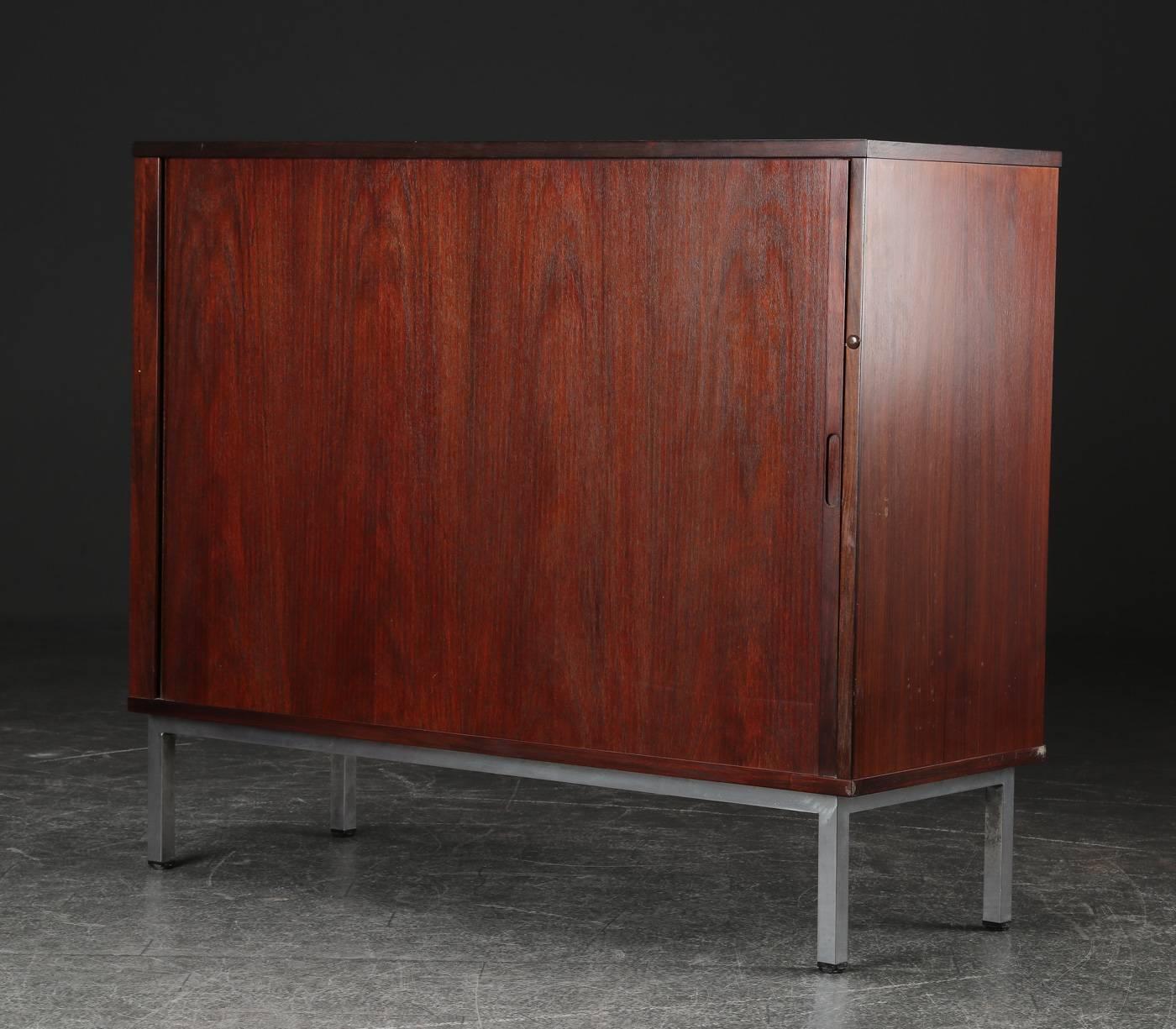 Cabinet veneered in hardwood with louvered doors, mounted with steel legs. Made in Denmark in the 1960s.
Great vintage design with interesting lines.

 