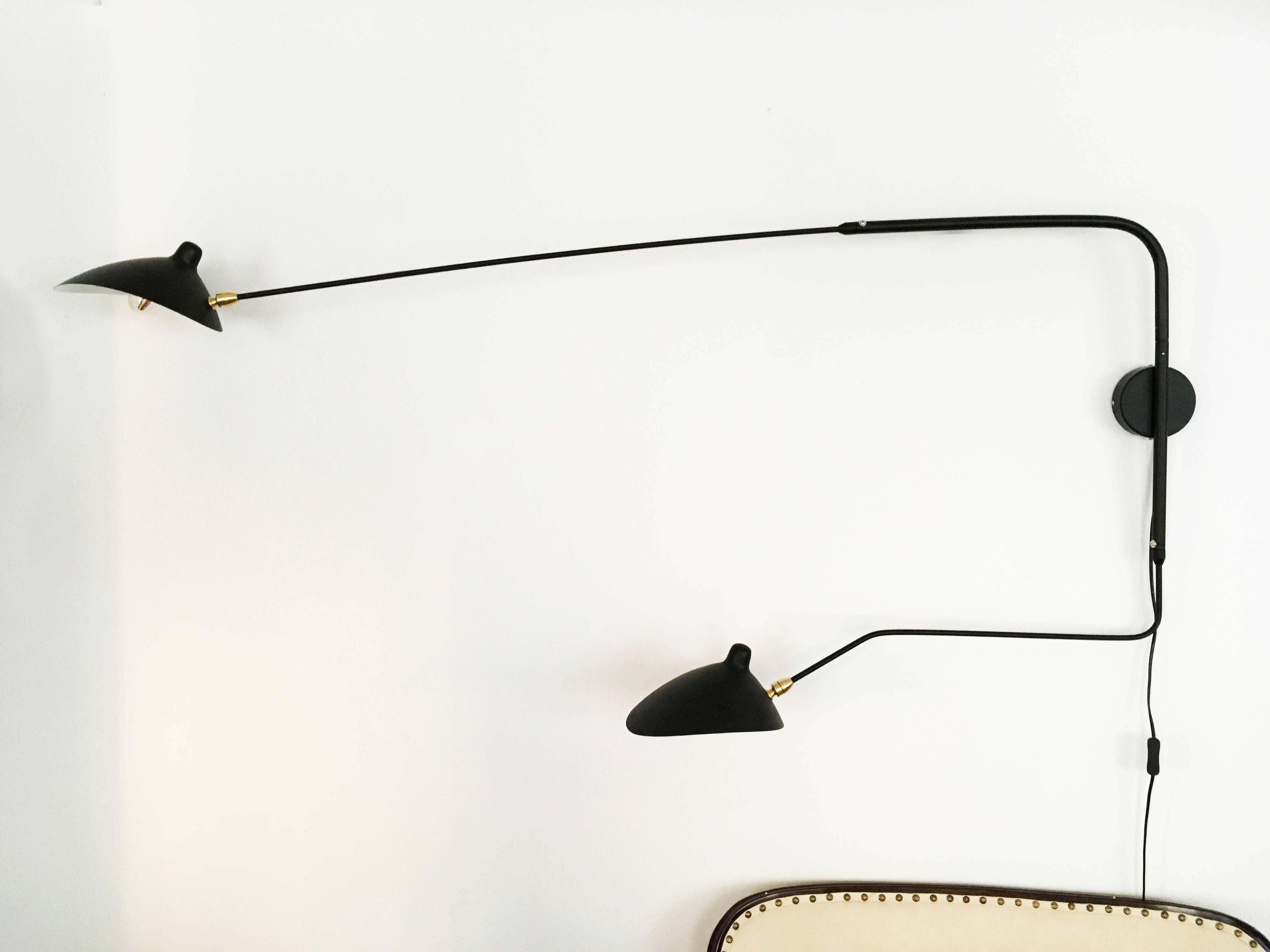 Large two arms rotating wall light made of brass and steel and aluminum shades black painted. Fitted with E14 sockets.
The lamp was originally designed by Serge Mouille in 1950s.
Dimensions: Arms 175cm 112cm , 
 height 75cm.

 
