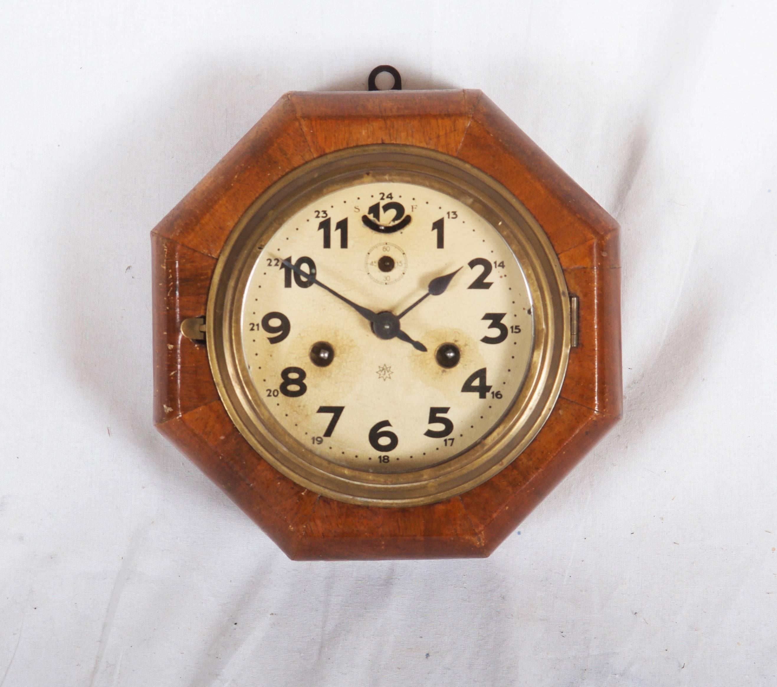 Walnut wood octagonal box, clock face with Arabic numbers, mechanical movement. Stil in original condition but on request also an electrical movement possible.
