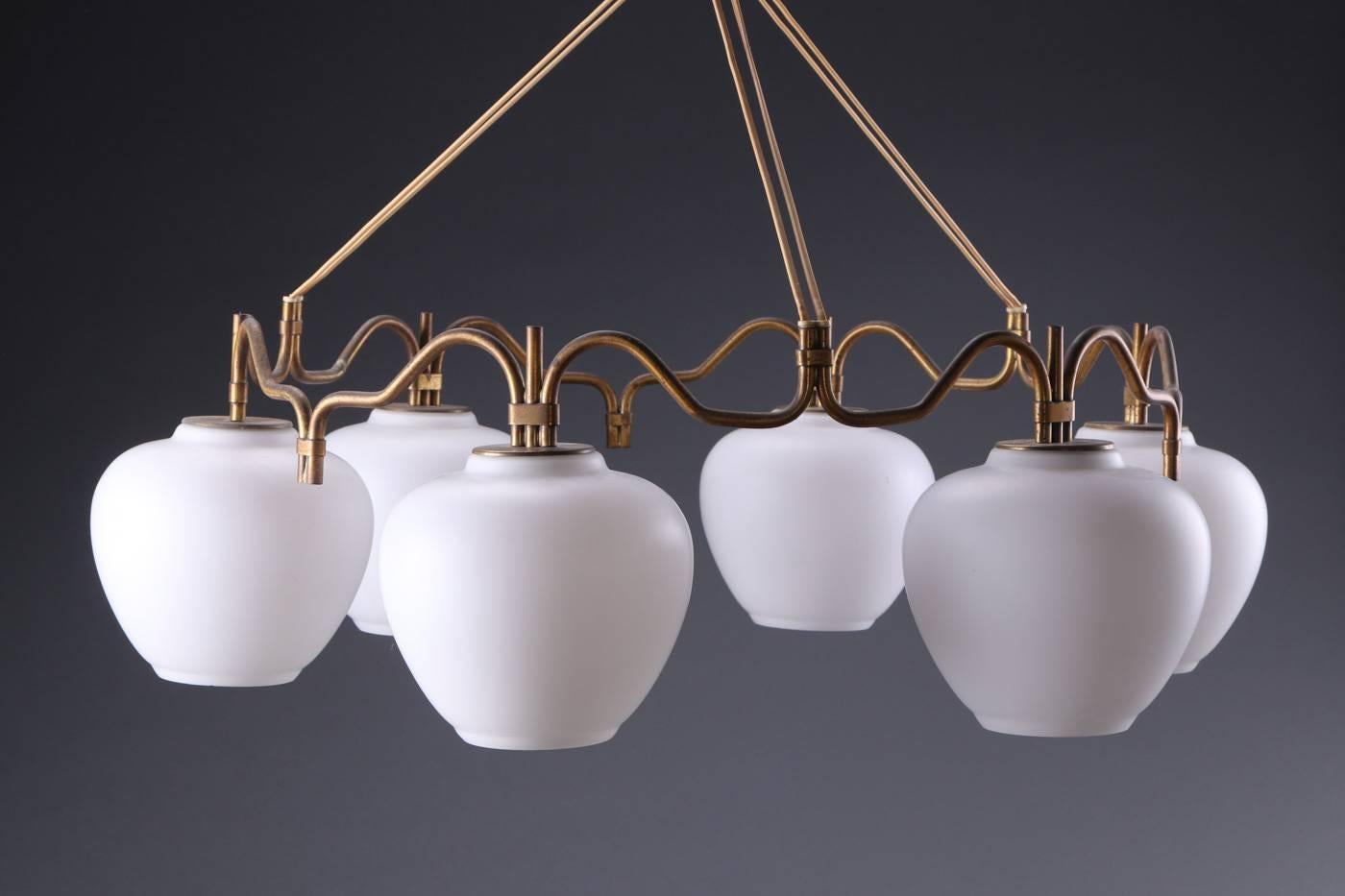 Brass construction with six opaline glass globes fitted with six E27 bulbs.
Designed by Bent Karlby for Lyfa in the 1950s in Denmark, model K 925.
Chandelier is suspended with vinyl cord from an original patinated brass canopy.