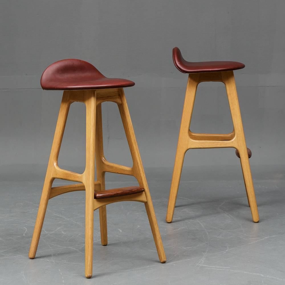Sculpted stools of oak and teak wood, seats upholstered in brown leather, model OD 61. Designed by Erik Buch in the 1960s for by O.D. Møbler in Denmark. 
Dimensions: 33.5
