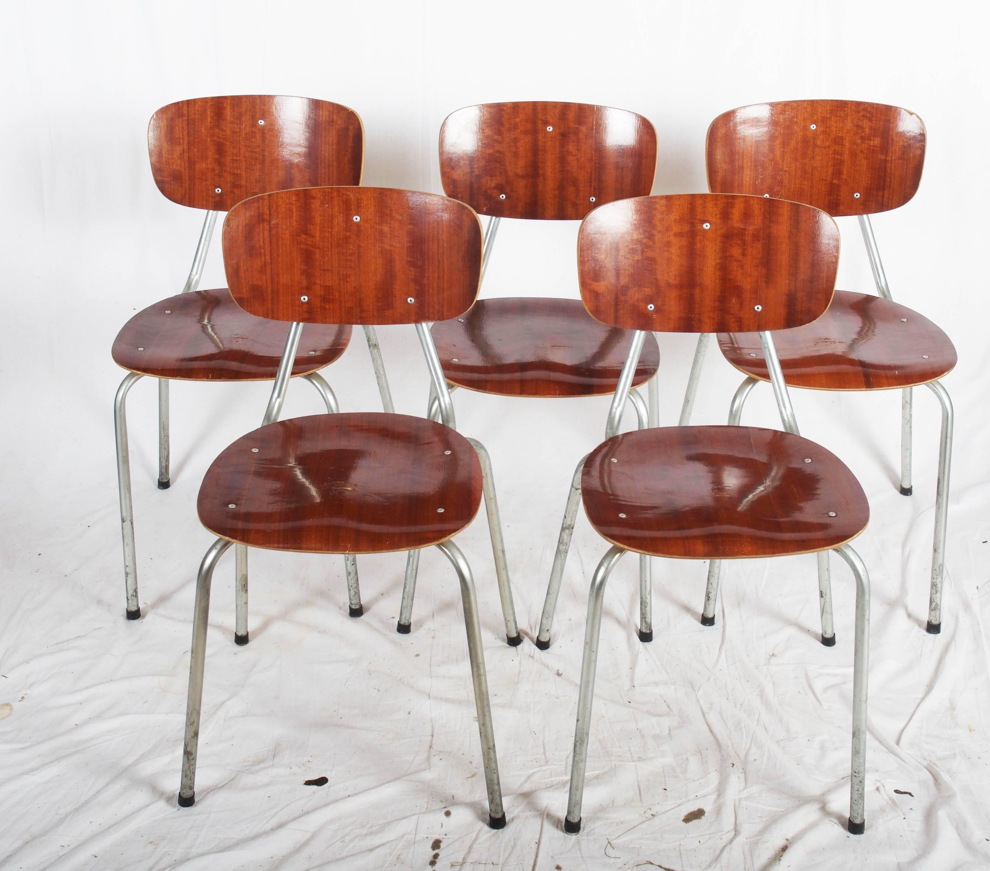 Five chairs, stackable, metal frame, seat and top rail veneered varnished beech. H. 76 Sh. 44 cm. Signs of wear, scratches, veneer chips, staple marks.