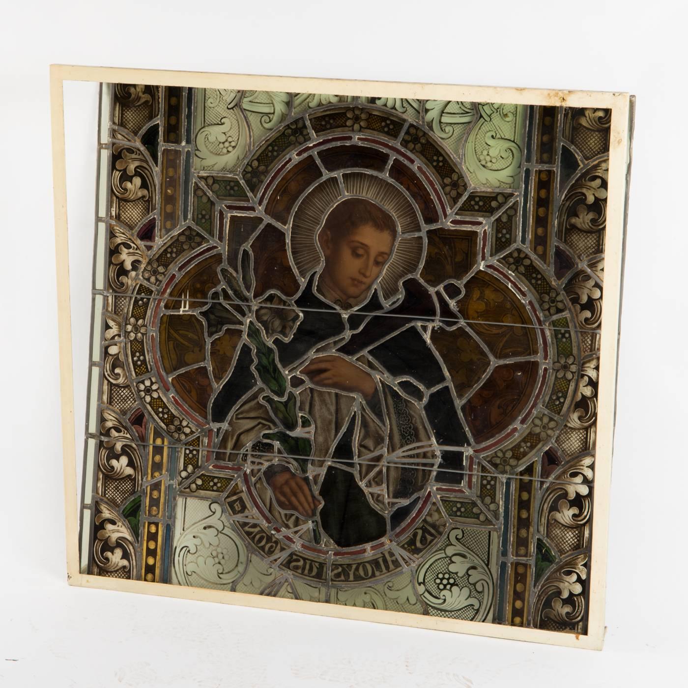 Hand-painted stained glass window from a German church probably form the early 20th century. It shows holy Aloisius from Gonzaga with a cros and a lily. The dimensions are 39" x 41".