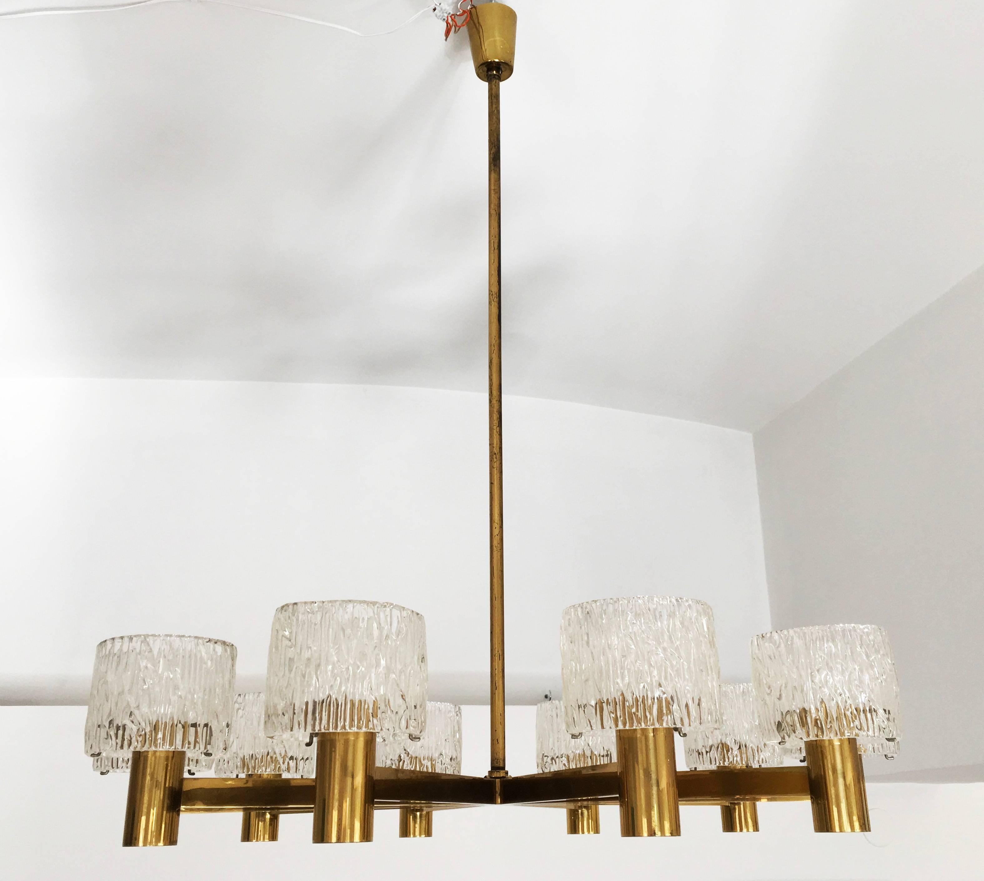Brass construction and cast crystal designed in the 1960s by Carl Fagerlung for Orrefors Glass Swedish. Fitted with E27 socketes. Modern chandelier with ten arms supporting cylindrical, heavily textured glass shades. Fagerlund was known for these