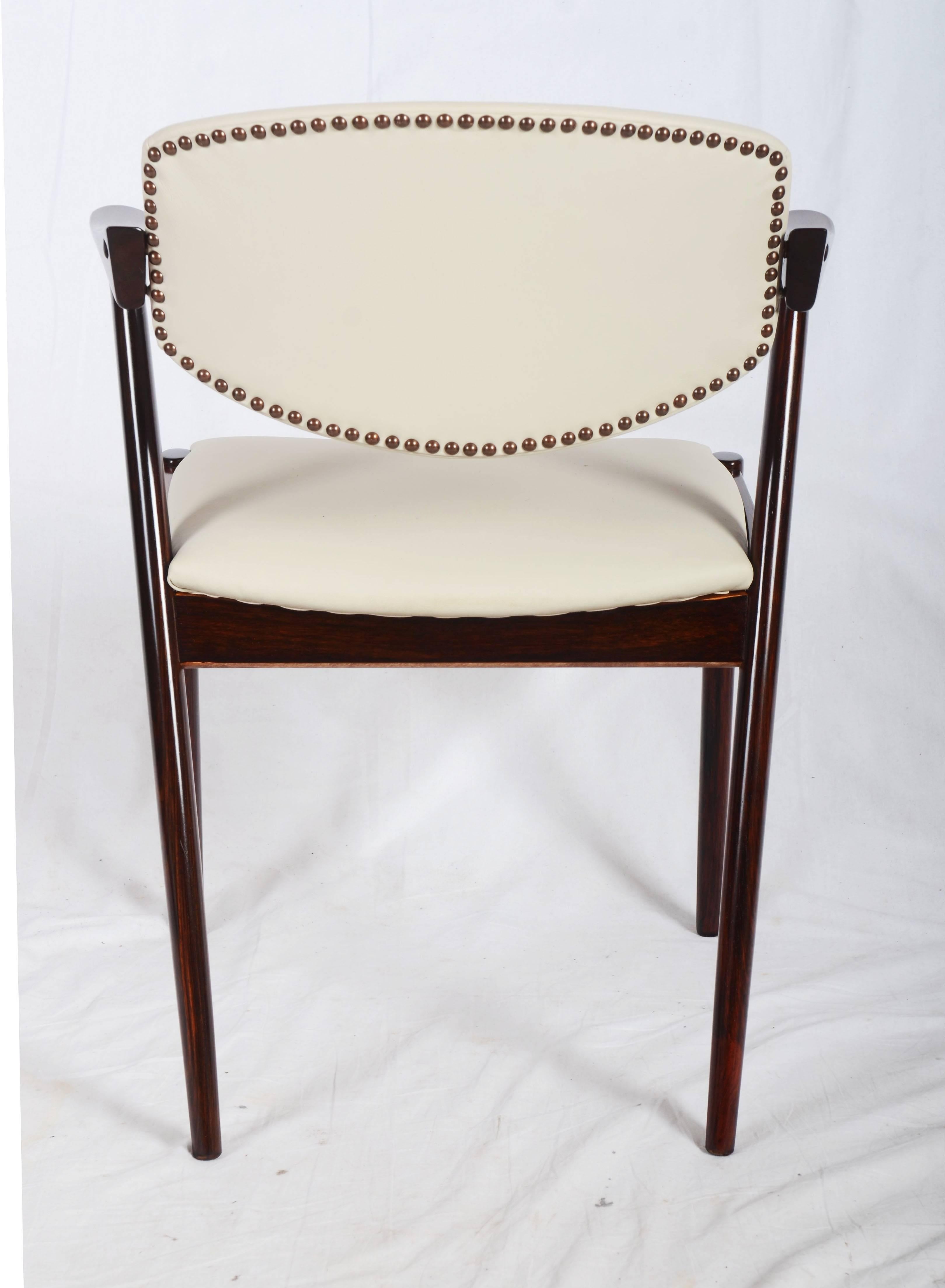 Esszimmerstühle, Modell 42, entworfen von Kai Kristiansen und hergestellt in Dänemark von Schou Andersen Møbelfabrik. Die Stühle sind aus massivem Hartholz gefertigt, haben konisch zulaufende Beine, geschwungene Armlehnen und eine cremefarbene