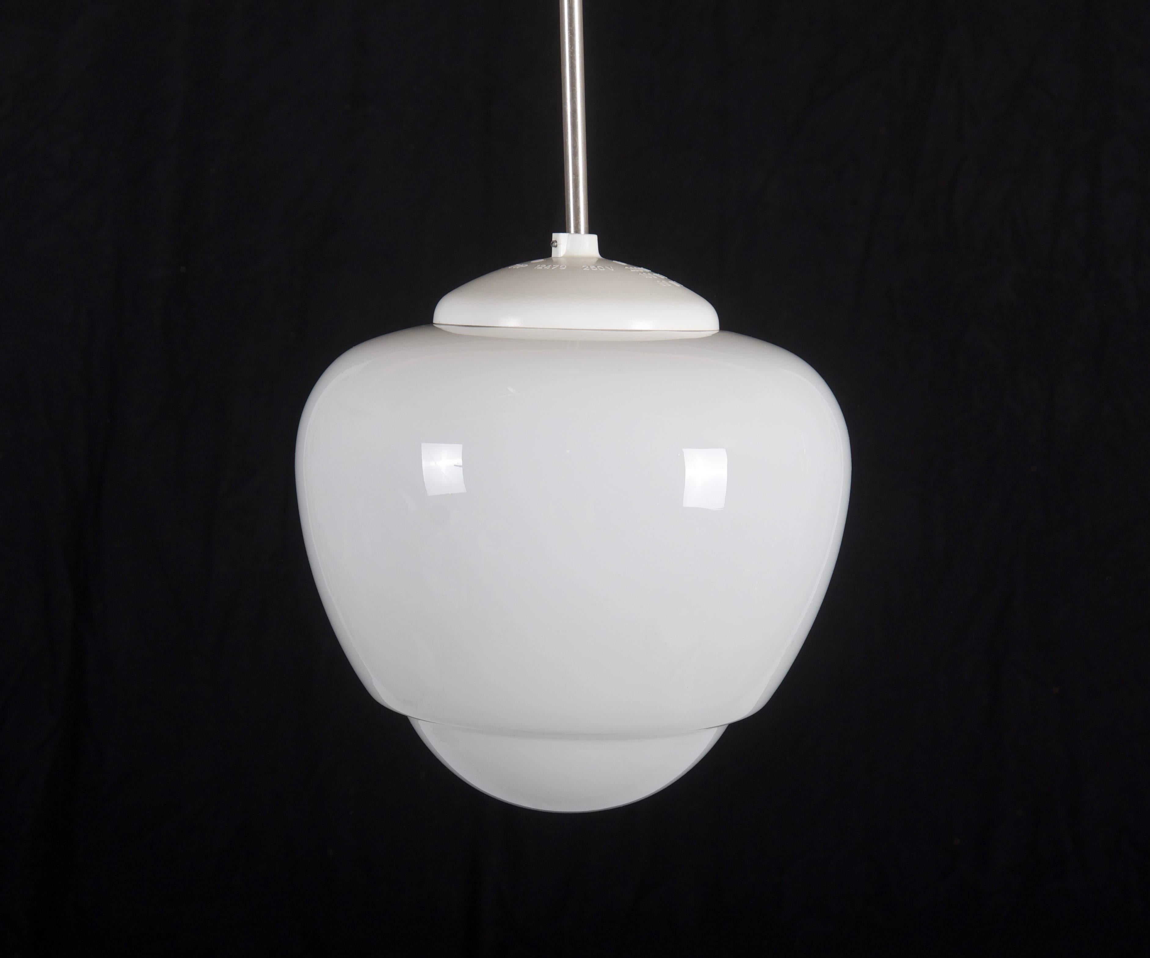 Bauhaus pendant from the 1940s.
Opaline glass shade mounted on a steel construction, cover and shade made of bakelite.
Up to five pieces available. (more on request).