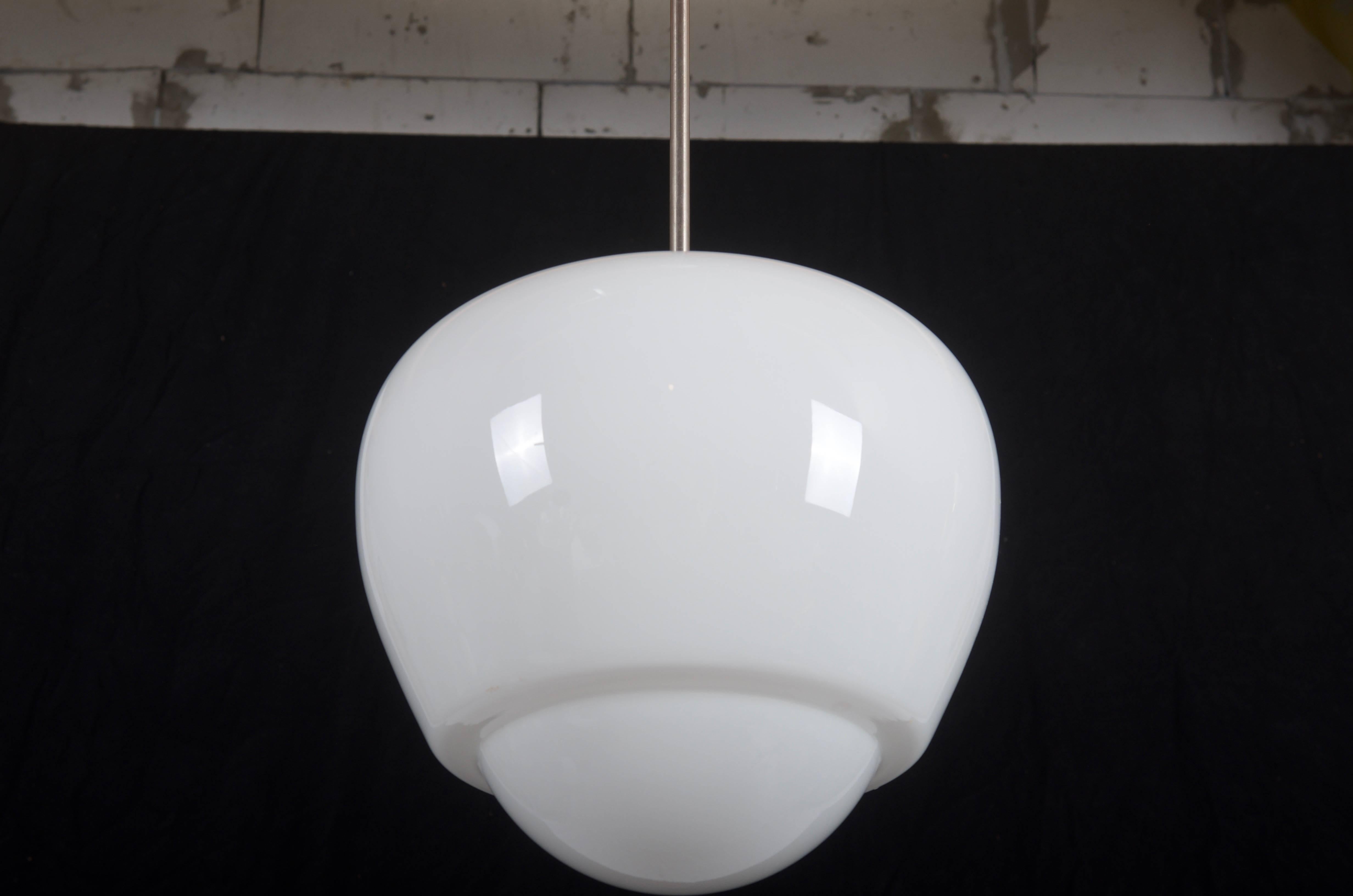 Bauhaus pendant from the 1940s.
Opaline glass shade mounted on a steel construction, cover and shade made of bakelite.
Up to 20 pieces available. (more on request).