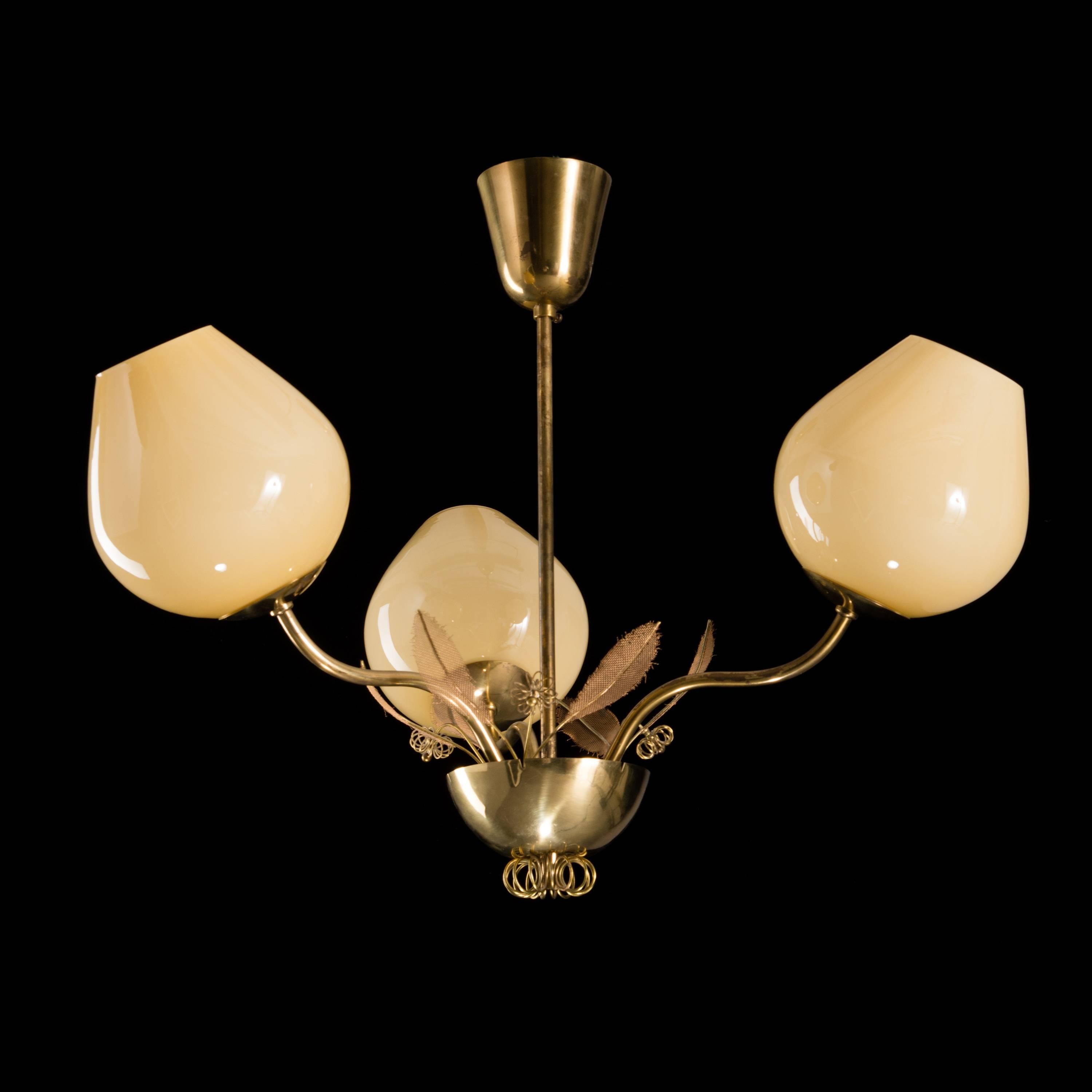Beautiful Paavo Tynell chandelier. Trademark leaves and brass roundedness surround the scalloped bras centre. Produced by Idman.