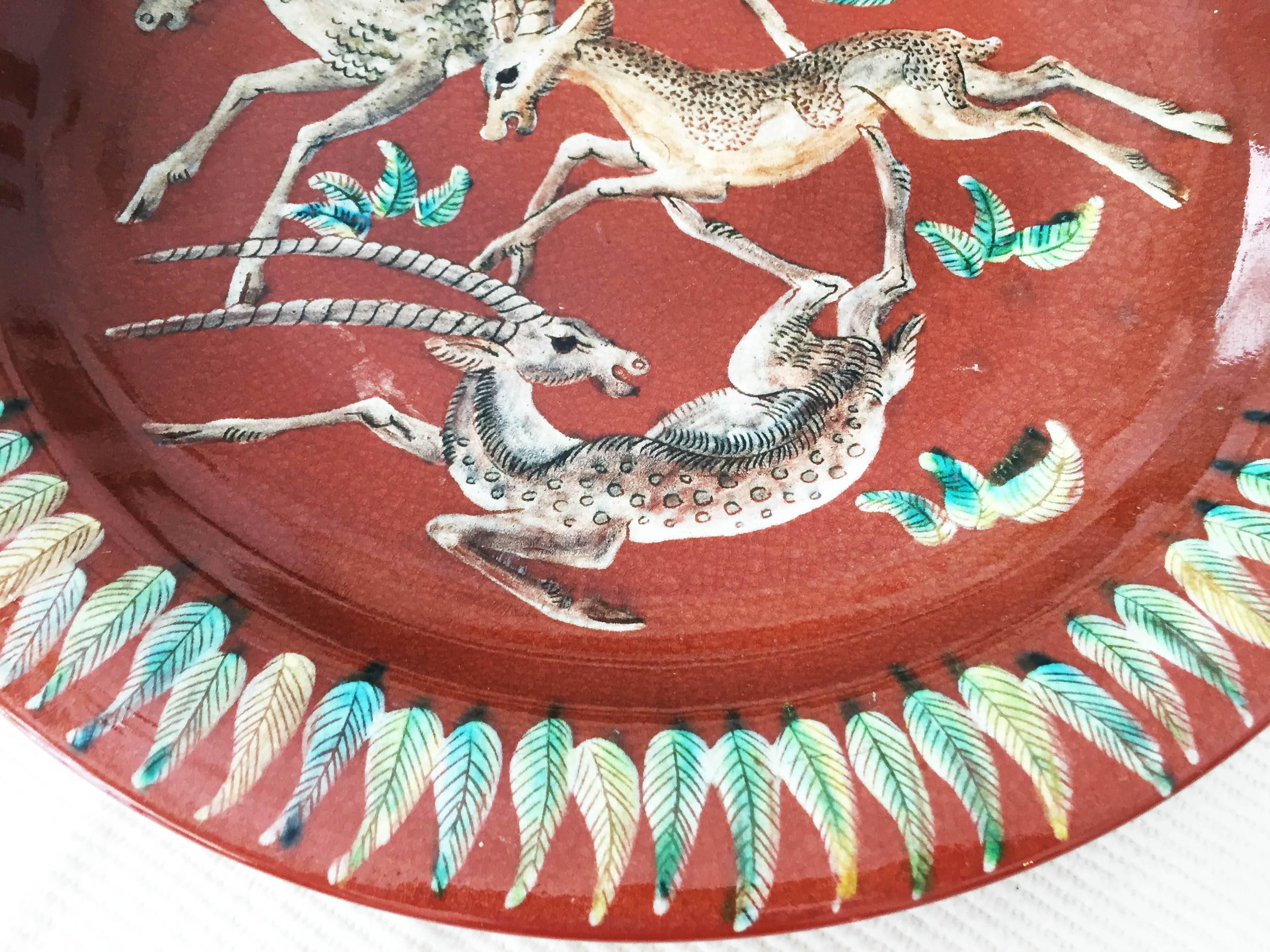 Very large Majolica wall plate of the Karlsruher ceramics tradition manufactory, probably circa 1940. Red-brown, glazed with antelopes decoration as a sub-glass painting. 
A perfect undamaged condition, see photos.
marketed on the underside with a