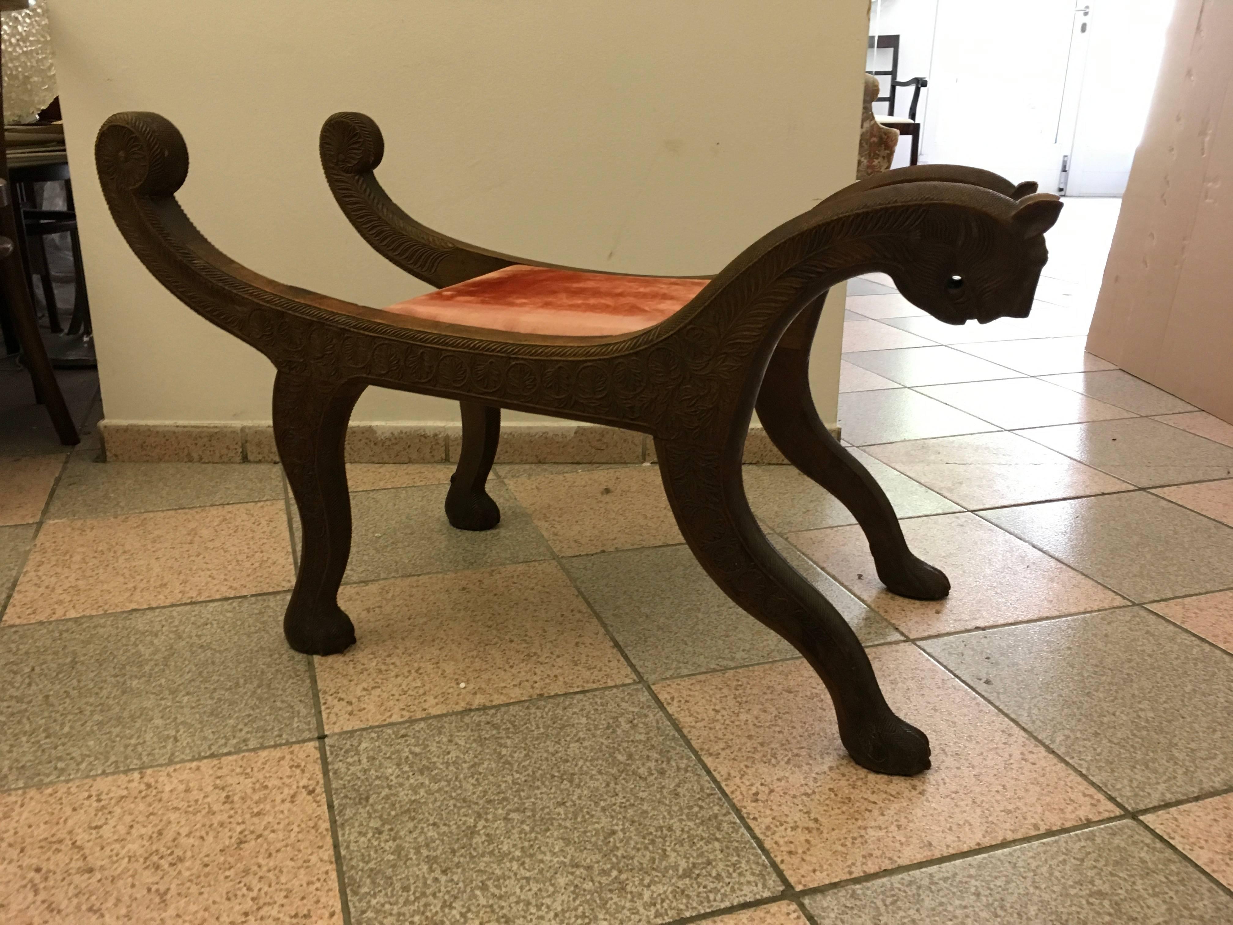 An Egyptian Revival style heavily carved wood and highly decorative, sculptural lion bench, or stool with upholstery.
Very good vintage condition with age appropriate wear.
