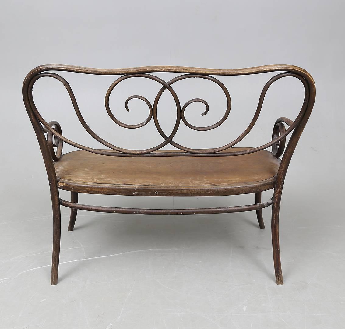 Beech bentwood construction with a caned seat (on the picture plywood) designed by August Thonet, he was the son of Michael Thonet, who in 1869 started to manage the family business. The settee from circa 1900, catalog number 1, is in a good