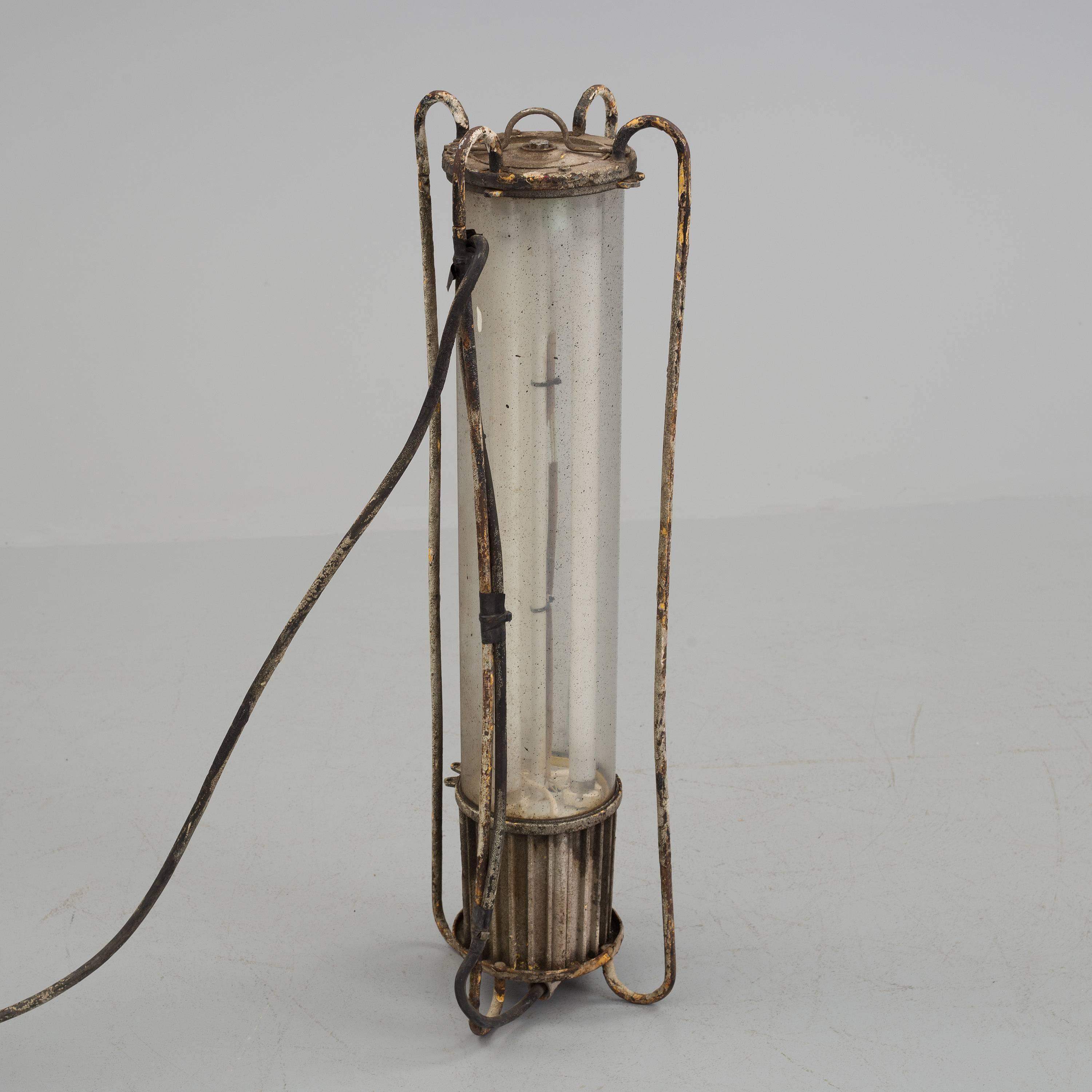 Steel/aluminum frame with a glass cylinder shade. Fitted with three tube lights.
Made in Sweden in the early 1950s, can be used as table or pendant lamp.
Original condition with nice patina, electric has to be renewed.
 
