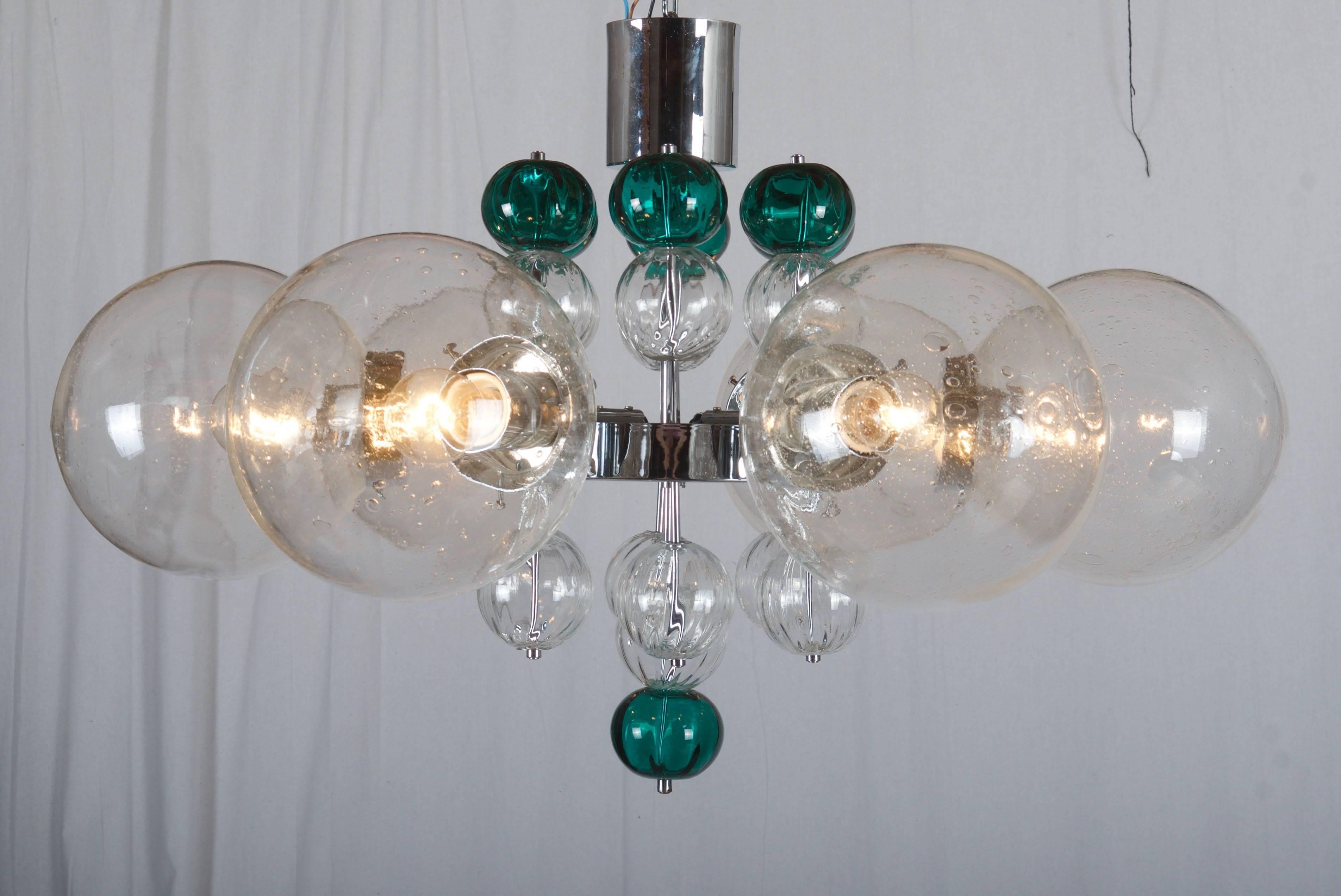Beautiful large chandelier with brass or chromed frame, six large handblown globes with air inclusions and 20 small handblown glass balls. Fitted with six E27 up to 100W each porcelain sockets.
This chandelier was made by Kamenicky Senov in the