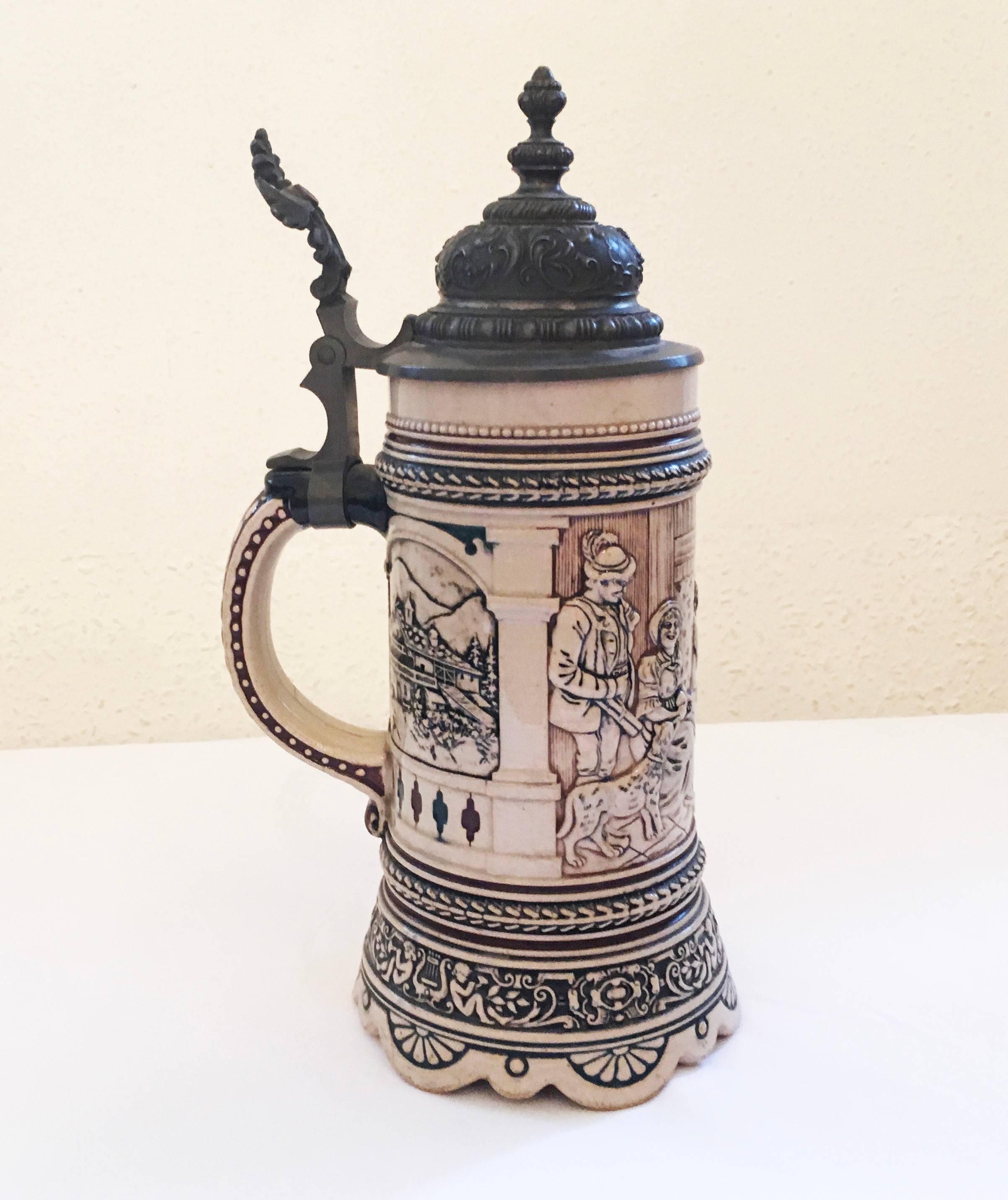 Stoneware 1/2 liter beer stein with an original pewter hinged lid. The body is decorated with a tavern scene.
Made in Germany, circa 1880.