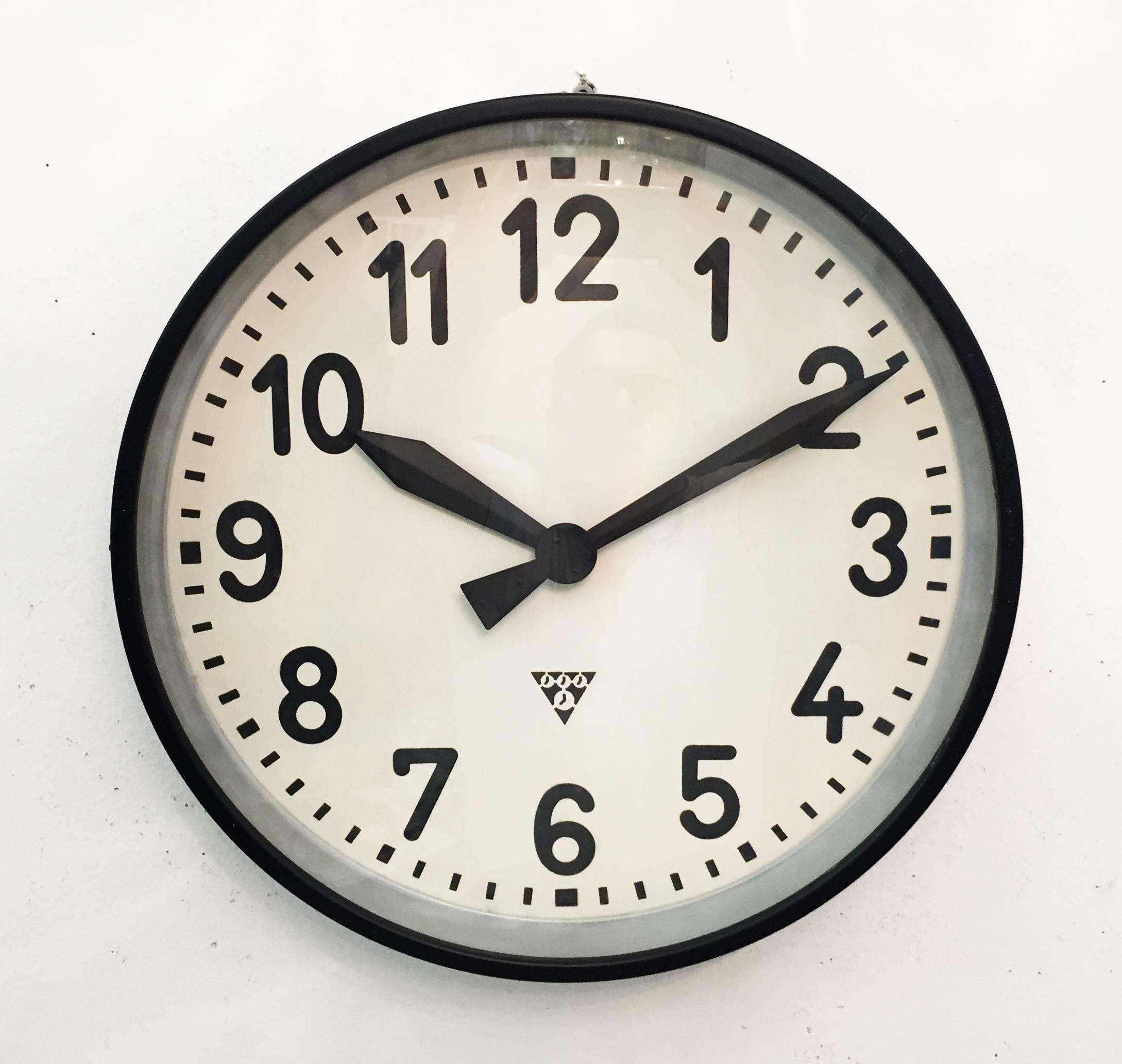 Industrial wall clock Pragotron. Frame made of a painted steel. The clock face is covered with glass. Formerly a slave clock, it is now fitted with a modern quartz movement with an AA-battery.