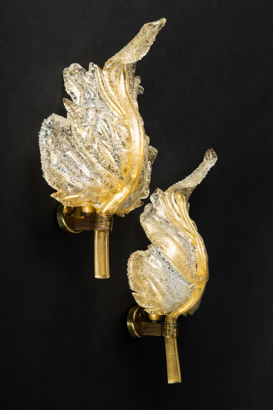 Pair of sconces, wall lamps in gold-painted metal and Murano glass with gold foils enclose, leaf-shaped diffuser with a focal point behind, inside with manufacturer's adhesive label
Dimensions: L 38cm, W 24 cm, T 12 cm
Excellent original