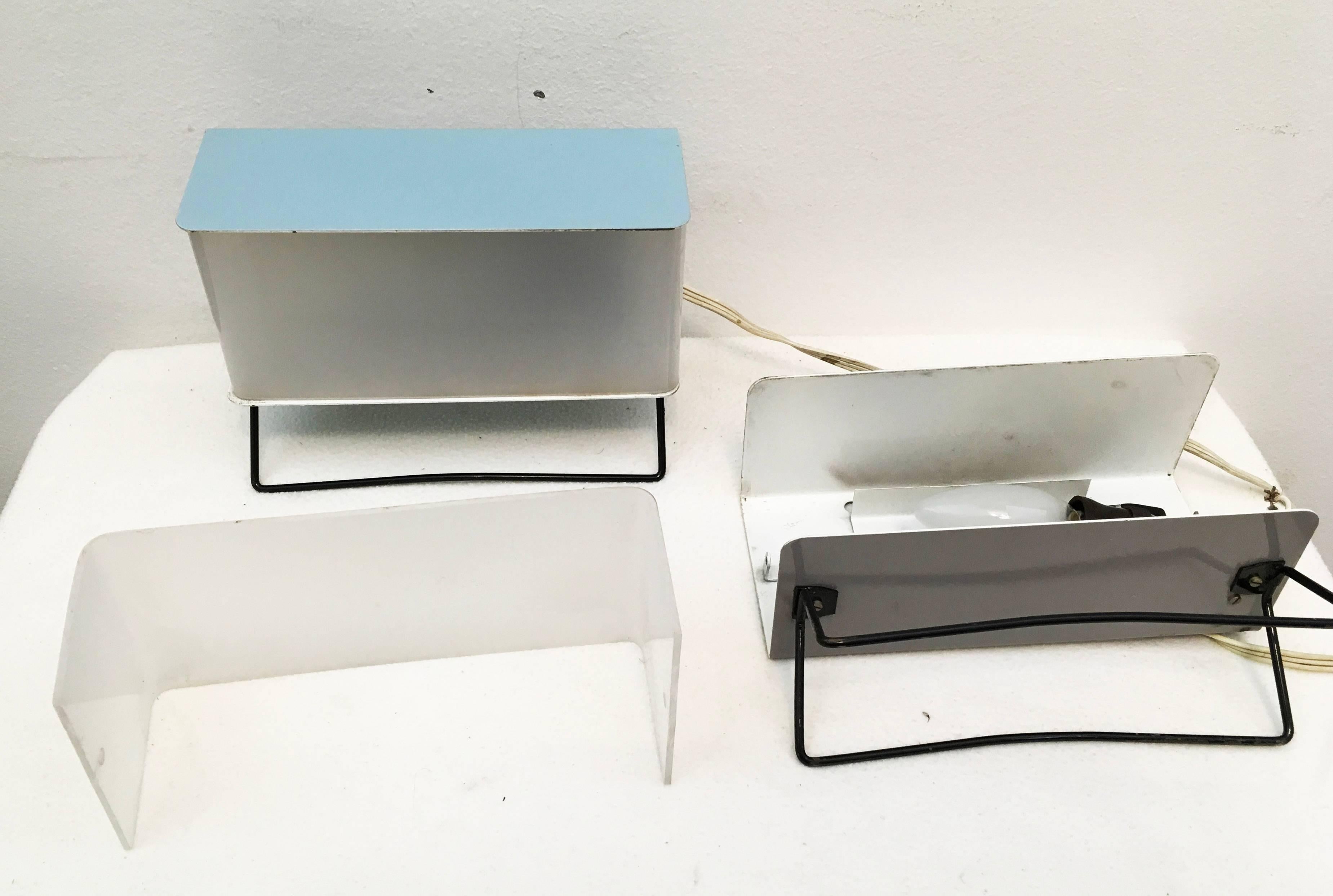 Pokrok Zilina lámpara de escritorio o sobremesa minimalista de diseño geométrico cubista
la caja es de metal una gris y otra azul pintada de metal con un frontal de plástico translúcido sobre una base de patines metálicos.
Muy buen estado