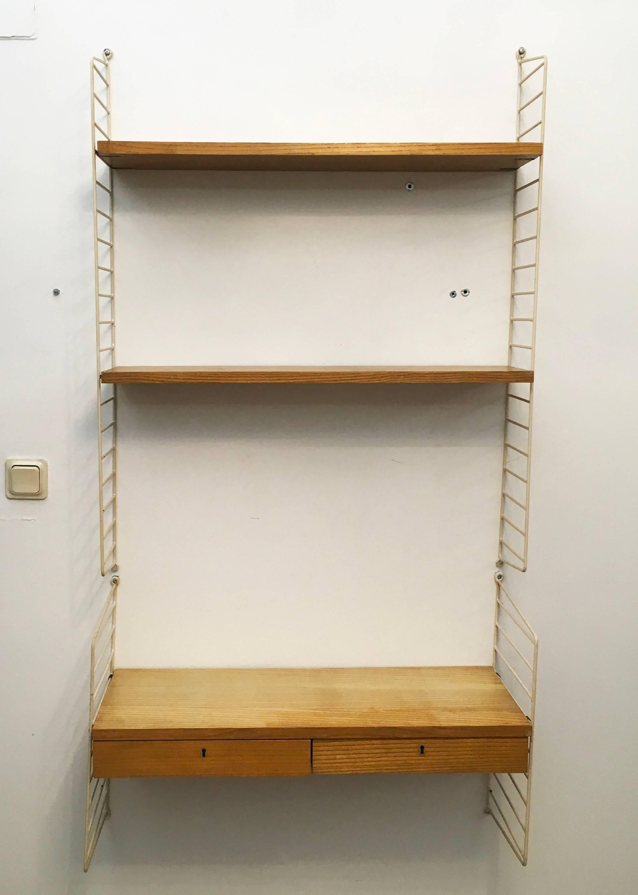 String regal wall unit designed by Nils and Kajsa Strinning in 1949. This one was made in the 1960s in Sweden.
A very good vintage condition, slight traces of use due to the age, nice patina.
Measures: Height 150 cm and width 80 cm.
Two ladders