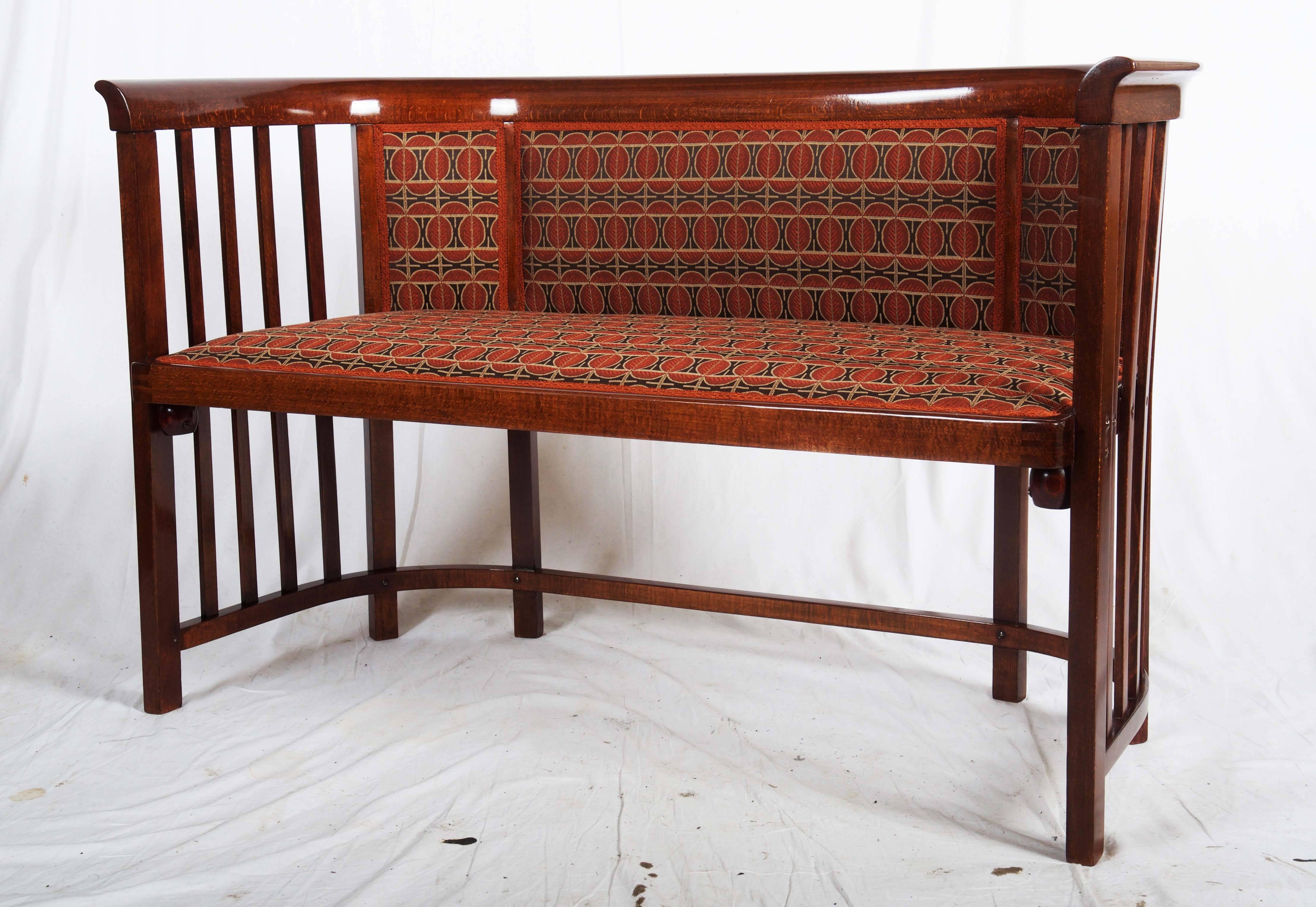 Beech bent wood bench manufactured by: Jacob & Josef Kohn, or Thonet Vienna (model NR. 423 F/ C) (the manufacturer label is missing). 
Mahagony coloured stained, seat and backrest padded. 

There are two more benches available but still not