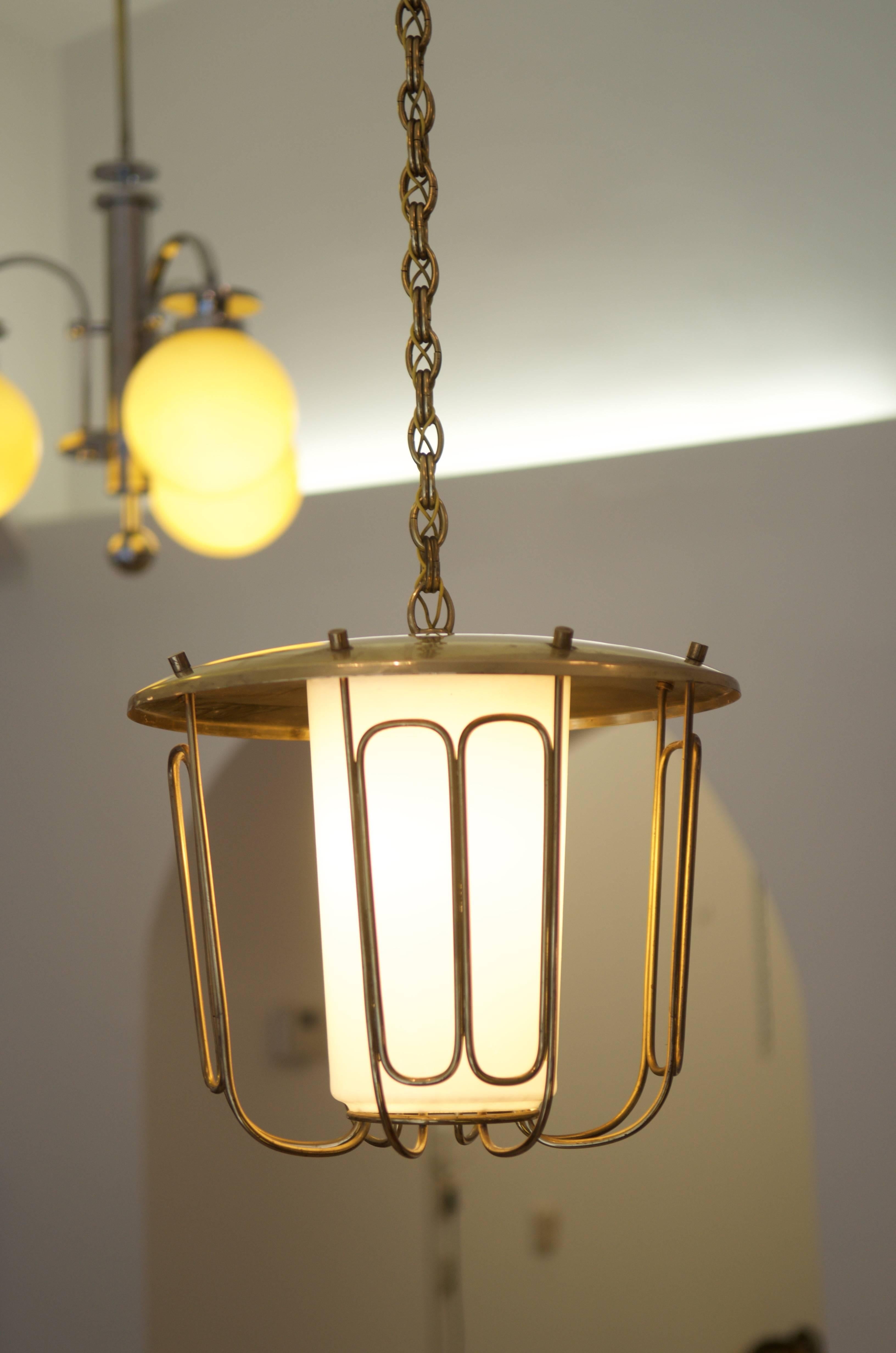 Brass pendant with milk glass inside the construction 
the total lenght is 145cm (57.08in) shortable.
