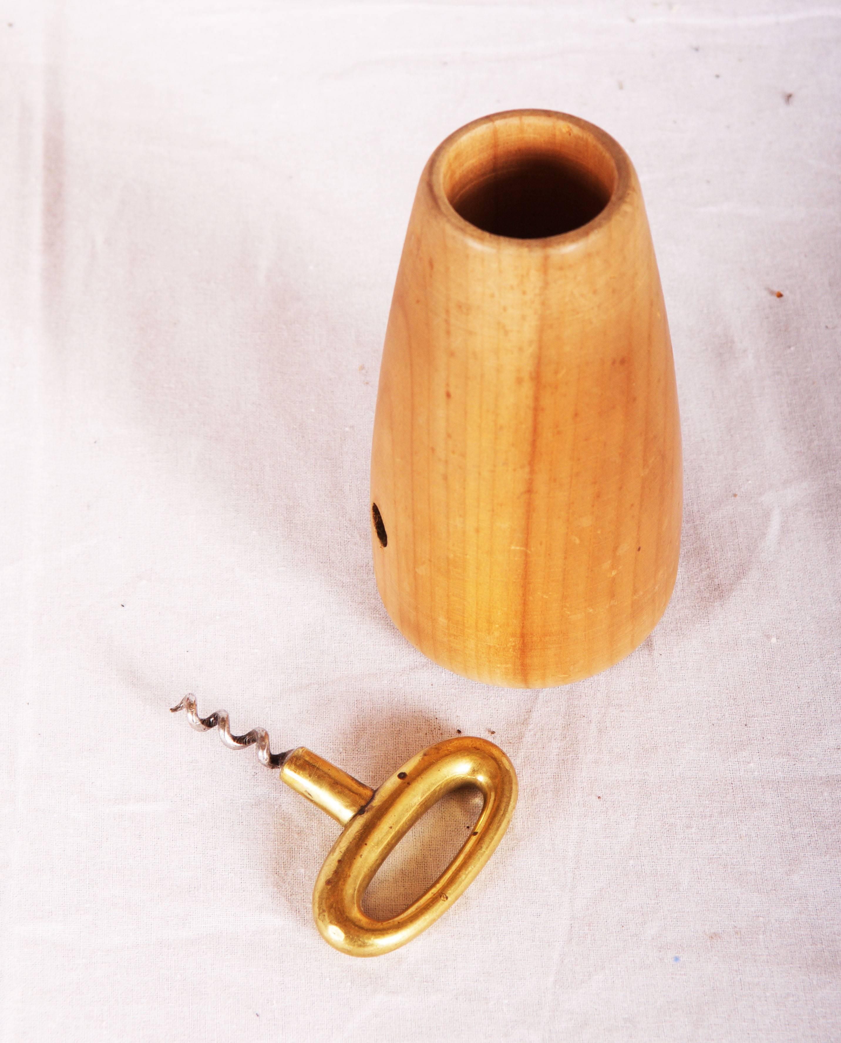 Brass corkscrew in a woooden round holder for toothpick.